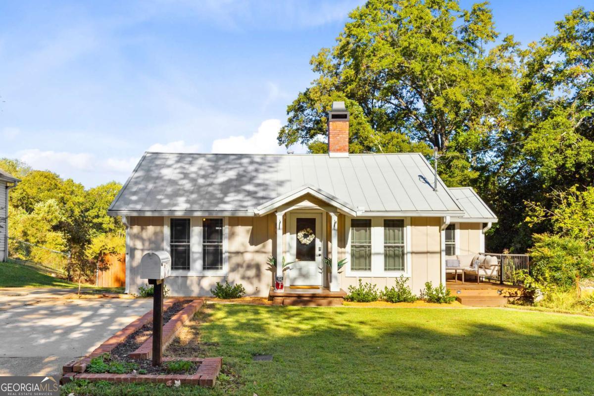 Prime Location in the Heart of Downtown Buford! Welcome to 399 Jackson Street, a charming and beautifully updated home ideally situated in one of North Georgia's most sought-after areas. Nestled just steps away from Historic Downtown Buford, this property offers unbeatable access to top-rated restaurants, boutique shopping, live music venues, coffee shops, and more-all within walking distance! This beautifully refreshed home boasts recent renovations throughout, offering the perfect blend of style, comfort, and functionality. Outside this home has a NEW STANDING SEAM METAL ROOF and a NEW HVAC - including new duct work and new registers in the home. There's more - NEW SIDING ON THE FRONT AND BACK OF THE HOME, NEW GUTTERS, and NEW EXTERIOR PAINT! Enjoy your morning coffee or evening drinks on your NEW SIDE AND REAR DECKING or play in the huge, flat, fenced in backyard! Inside this showcase home has recently been added a NEW SLIDING DOOR, A NEW CLOSET SHELVING SYSTEM AND ENGINEERED HARDWOOD FLOORING. The interior is recently painted and has a ton of natural light with new windows throughout, vaulted ceilings, a sizeable dining area, oversized primary bedroom with a huge walk in closet and 2 additional bedrooms and 2 baths. The kitchen provides plenty of cooking and storage space. An added bonus is a partial basement with exterior entrance for storage. Don't miss out on this rare opportunity to live in Buford. Consistently ranked among the top-performing public schools in Georgia, this district is known for its academic excellence, elite athletic programs, and supportive community. Homes within this district are in high demand-and this one is a true standout. CHECK OUT THE VIDEO LINK FOR A TOUR OF THE HOME