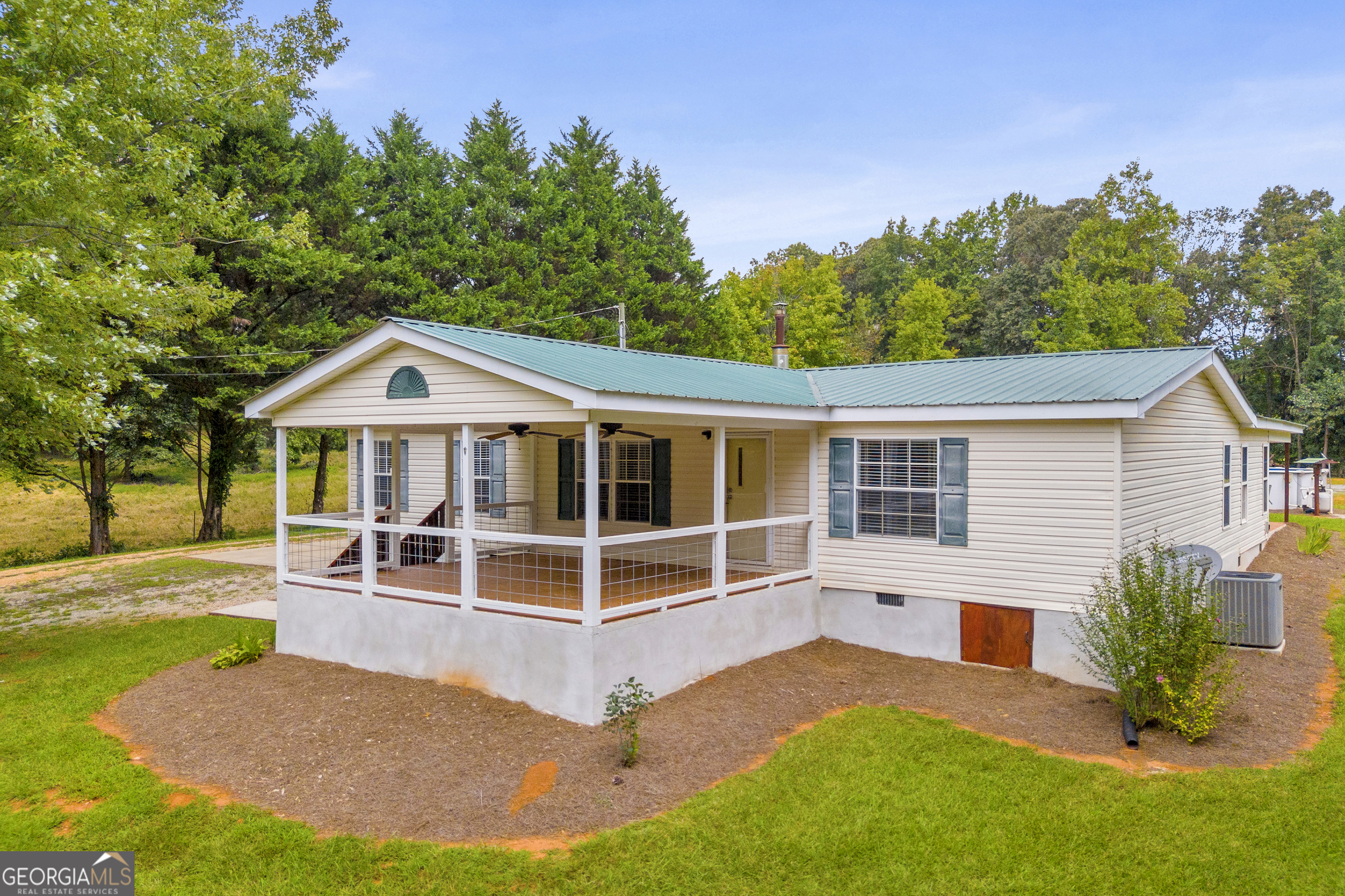 Welcome to peaceful country living in this charming 3-bedroom, 2-bathroom manufactured home in Hall county, perfectly set on nearly 2.5 acres with a serene pond view and a creek on the back side of the property. Inside, you'll find a flexible bonus room that can easily serve as a 4th bedroom, office, or playroom that is filled with natural light and accented by beautiful wood ceilings and walls while offering cozy carpet for comfort. The main living area features easy-to-maintain solid surface flooring, wood burning stove to keep you cozy on those cool fall and winter evenings. The spacious owner's suite features an en-suite bath with a double vanity, relaxing soaking garden tub, and separate glass shower. The additional bedrooms are just off the main living room with plenty of closet space for storage. Step outside to enjoy your morning coffee on the covered front porch, take in the peaceful pond view, or spend sunny afternoons splashing in the above-ground pool. With plenty of room to spread out and relax, this Lula property within the sought after North Hall school district offers the perfect blend of comfort, charm, and outdoor living that's still convenient to Gainesville for shopping, health care and more.