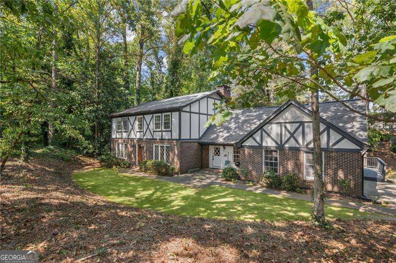 Endless Possibilities in Prime Sandy Springs Location! Extraordinary opportunity in the heart of the prestigious Riverside neighborhood. Nestled on a private 1.00-acre corner lot, this classic Tudor-style residence offers unmatched potential in one of Sandy Springs' most desirable locations and the pictures show what a few updates like new floors and a coat of paint can do! Zoned RE-1 Residential Estate and located in the top-tier Heards Ferry Elementary, Ridgeview Charter, and Riverwood International Charter school districts. Whether you're envisioning a custom-built dream estate or seeking a prime renovation opportunity, this property delivers. Set well back from the street, the home features traditional charm, generously scaled rooms, and unique architectural elements. The main level offers multiple living spaces, including a welcoming foyer, formal living and dining rooms, a cozy family room with wood-beamed ceilings and brick fireplace, and a kitchen with breakfast area. An additional main-level bedroom with full bath could serve as a guest suite or smaller primary bedroom. One of the home's most captivating features is the sun-drenched solarium-a dramatic space with cathedral ceilings, skylights, built-ins, wet bar, and even a hot tub-ideal for year-round entertaining. This space opens to a large deck overlooking the expansive backyard. Upstairs, the oversized primary suite includes its own sitting area with fireplace, enormous walk-in closet, and full bath-along with potential for further attic expansion. Two additional bedrooms and a full bath complete the upper level. The terrace level features a finished recreation room perfect for a media space or game room, plus two large unfinished areas offering endless options for storage or future expansion. Outdoor living and expansion potential is a huge plus! The newly fenced backyard is ideal for pets and outdoor recreation, with ample room to add a luxury pool, outdoor kitchen, or full-scale addition. The property line extends well beyond the current fence, offering even more usable land. A public sewer line is accessible nearby on Heards Creek Drive NW, adding value and flexibility for redevelopment. This coveted address offers quick access to I-285, top-rated schools, the Chattahoochee River, local parks and trails, premier golf courses, shopping, dining, and everything that makes Sandy Springs one of metro Atlanta's most sought-after communities. Whether you renovate or rebuild, this home is a rare canvas in a legacy location. Bring your vision-and make it extraordinary.