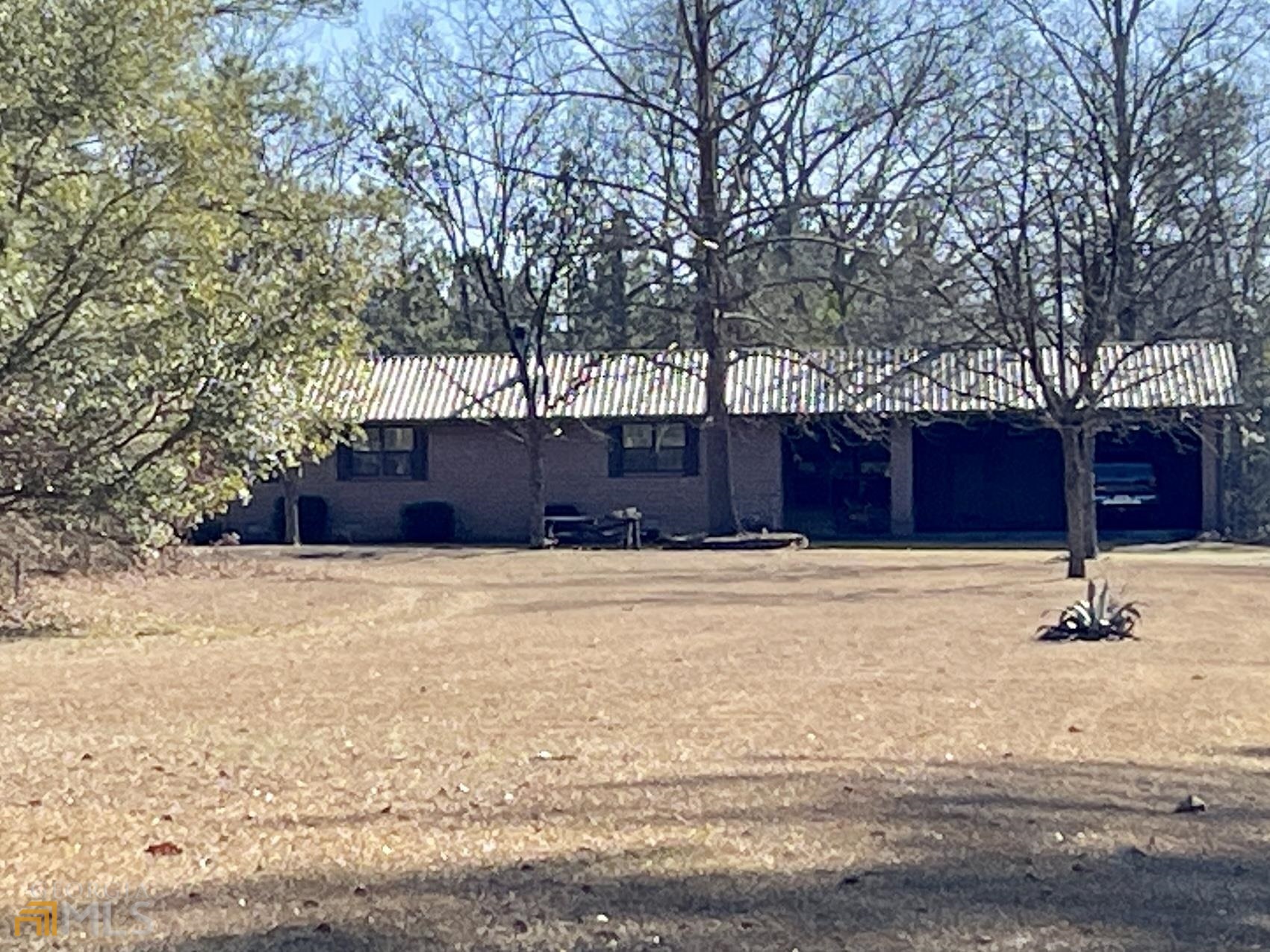 GET AWAY FROM IT ALL! This well maintained brick ranch home with over 1500 sq. ft. is located in the middle of a gorgeous almost nine acre tract. You can sit on your front porch, back screened in porch, or on your patio that's just off the master bedroom, and experience complete solitude. The home includes 2 bedrooms, including a huge master bedroom, and 2 full baths. If you need more room to spread out, there is a 30x40 shop with central heat and air, a wood stove, two roll up doors, and a huge room that's plenty big enough to use as another bedroom, or party room, whichever is most needed! and if you still need more, connected to this building is a 30x50 that also has 2 rollup doors, and a full bathroom with a large walk in shower. The property also features 2 more storage buildings (one with electricity, and the other is wired). If it's the seclusion you are looking for, you have found it! Call today before it is gone!!