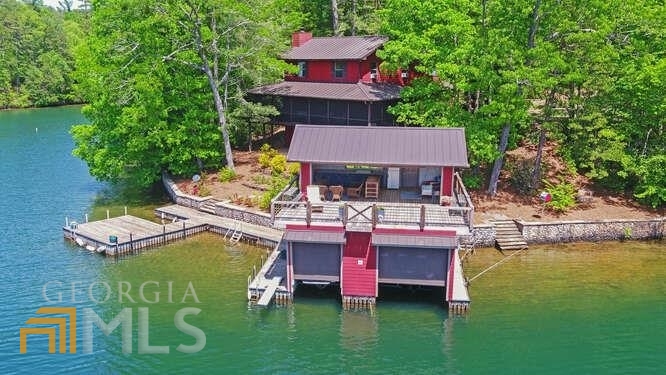 Rare opportunity with lake front property on Lake Rabun. Charming lake home with 5 bedrooms and 3 baths. 2 car attached garage with parking pad. Main level offers kitchen and living room with wrap around screened in porch, overlooking the water. Upper level has 4 bedrooms and 2 baths as well as bonus space above the garage. Terrace Level has recreation room, bedroom and bath. Recently added 2 boat house and floating dock, ideal for entertaining. Best lot on Lake Rabun. Truly must see!