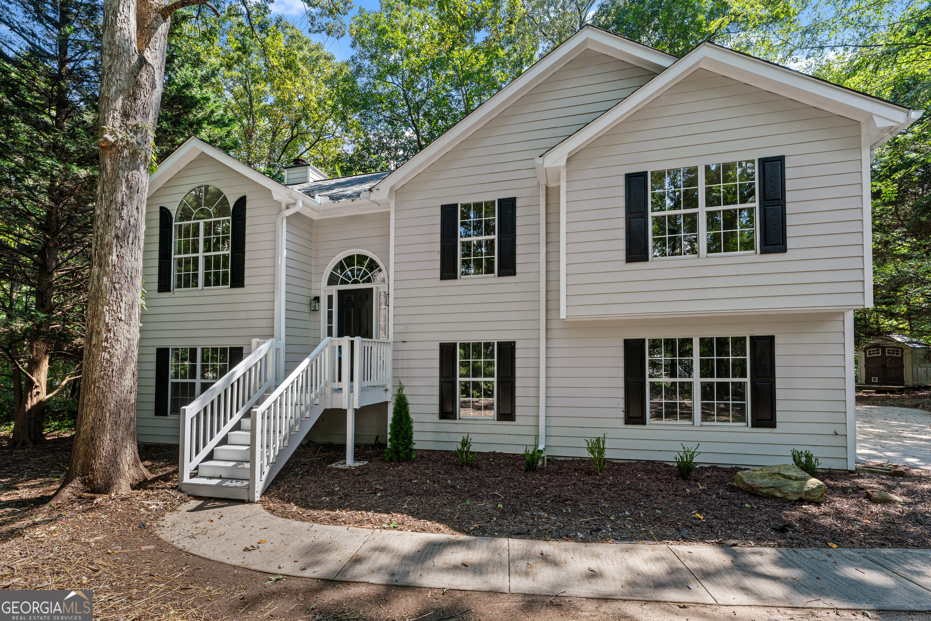 R.E.N.O.V.A.T.E.D. All the polish of new construction BUT without the postage stamp lot or HOA rules. Set on a wooded acre in the NEW Heroes Elementary School District, this BETTER THAN NEW CONSTRUCTION where a modern refreshed home delivers a spacious layout, long driveway, mature privacy, and on trend finishes. Luxury laminate flooring carries seamlessly through the main living areas, while the bedrooms offer newly laid, soft-to-the-touch carpet for cozy comfort. The heart of the home, the kitchen has been totally reimagined with soaring ceiling height new cabinetry, Corian countertops, a baked scone tile backsplash, and a full suite of stainless appliances. Every bathroom was gutted and rebuilt in a serene, spa-like style featuring marble looking tiled floors, brand new vanities, new mirrors, tiled tub surrounds, and new toilets. The owner's suite bath is the ultimate glow up, starring a show stopping (or shall we say shower stopping) deep, freestanding soaking tub-your personal retreat at the end of the day. A layout that truly adapts to all the needs - Enjoy 3 bedrooms/2 baths on the main level plus 2 additional bedrooms and a full bath on the lower level-perfect for multigenerational living, extended stay guests, or dedicated spaces for work, fitness, and play. Both levels open to their own outdoor decks, inviting you to spread out and savor the green, serene setting you won't find in most new construction.