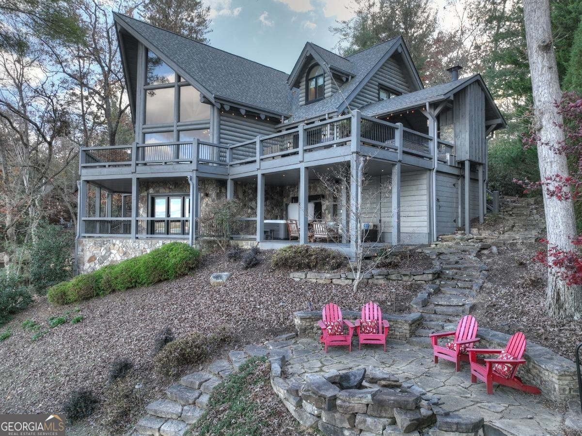 This true log abode on Lake Blue Ridge is beyond captivating. Upon arrival, you will notice this lodge was built to showcase the lake and mountain view - you will truly feel as if you're on the water from the moment you walk in the door! With the logs painted a light neutral shade that complements the modern finishes and rustic elements throughout, this showstopper puts a modern rustic spin on the classic cabin... the best of both worlds! The main level offers an open living room, dining area & chef's kitchen with the primary suite, half bath and party porch off the living space. The upstairs offers two additional bedrooms and baths. Delight guests on the terrace level with a large living area overlooking the view, spacious game room with bar, double laundry room, bathroom, bedroom with built-in bunks, and easy access to the waters edge. Although there is an amazing amount of space to entertain and sleep guests, this lodge also has a cozy intimate feel when all your guests are gone. Other highlights include three fireplaces, multiple firepit areas, new granite countertops, stainless appliances, tile showers, covered parking, and it includes the boat, dock, and furnishings. This 4BR/4.5BA retreat is perfectly positioned to enjoy privacy and is less than 10 minutes to downtown Blue Ridge - the ultimate lakefront location with the ultimate view.