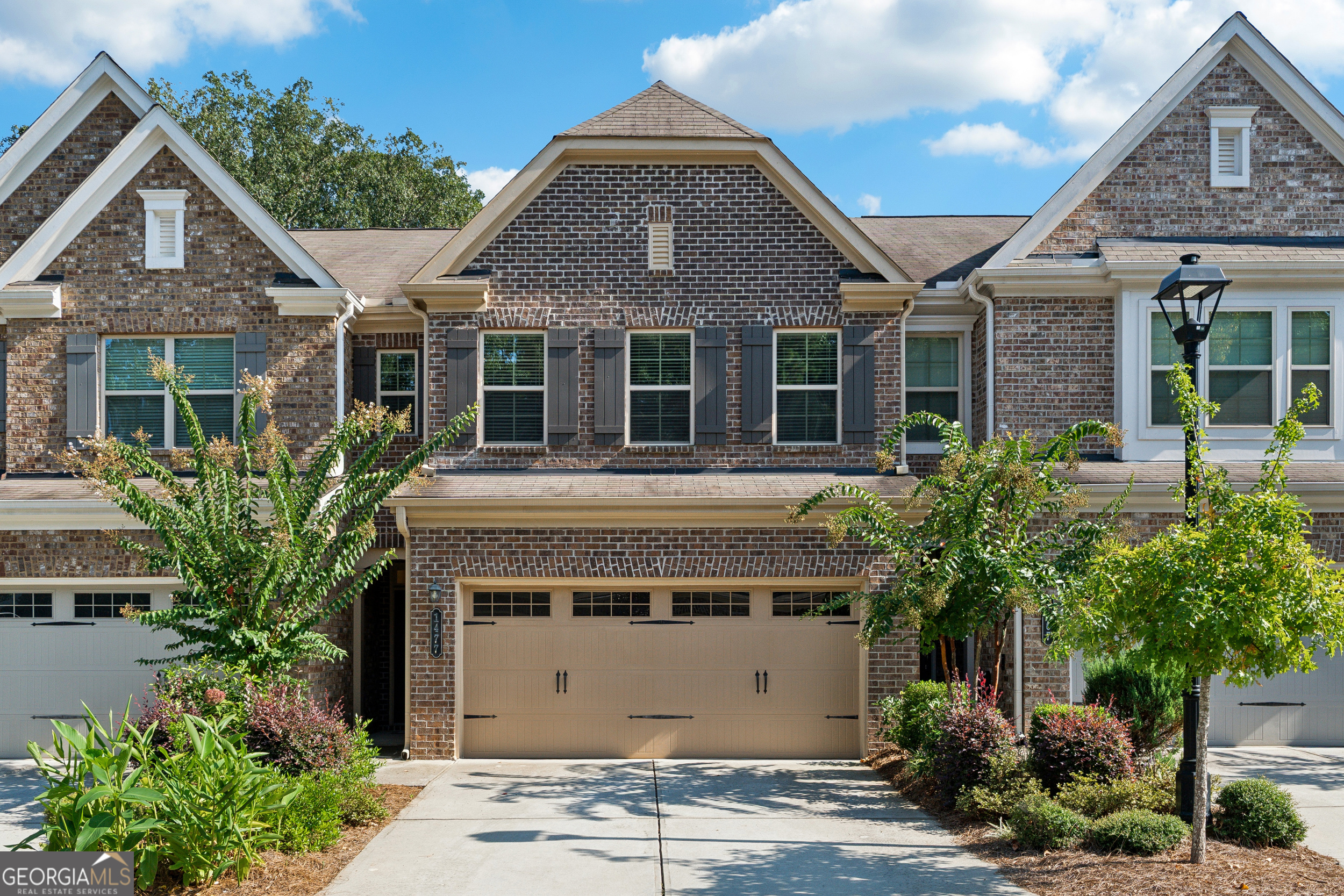 Welcome to 1477 Lanier Vista Drive! This beautifully maintained 3-bedroom, 2.5-bathroom townhome is located in the highly sought-after gated community of Lanier Park in Sugar Hill. Featuring an open-concept floor plan, the main level offers a warm fireside living room that flows into the dining area and a well-appointed kitchen with stained wood cabinetry, granite countertops, and a spacious walk-in pantry. Upstairs showcases hardwood flooring throughout, a large primary suite with a soaking tub, separate shower, and dual vanities, plus two additional bedrooms and a convenient upstairs laundry. Enjoy outdoor living with a private patio and newly fenced backyard, perfect for pets or entertaining. Additional highlights include a 2-car garage, abundant natural light, and access to a community pool and secure gated entry. Located minutes from shopping, dining, and top-rated schools, this townhome offers comfort, style, and convenience in one of Sugar Hill's most desirable communities.
