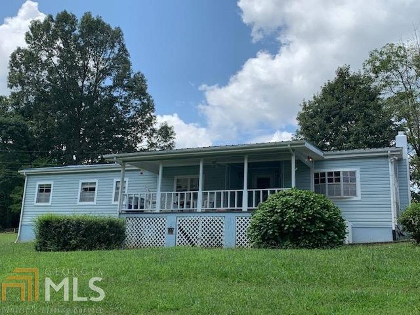 Double lot, well maintained property with Lake views all year and exceptional seasonal views. Wood Laminate flooring in all main living areas, carpeted bedrooms. Jack and Jill between 2 guest bedrooms. Office or Den area leading out to the Large Sun Porch, which runs the entire length of the back. Master bath has double sinks, tub, and separate shower. Great Front Porch with swing to enjoy the views. 12X20 Outbuilding with loft. Double Carport. Good looking yard. RV hook up.