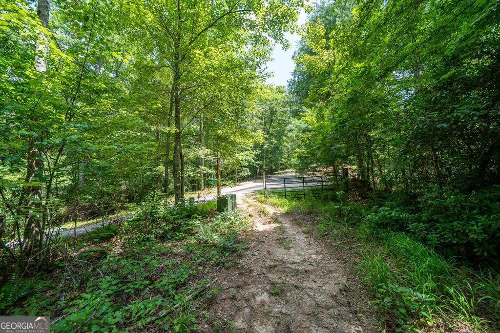 2.31-acre parcel located at the end of Christy Ln in Lumpkin County, Georgia. This property features a mix of wooded terrain and gentle slopes. A gravel driveway leads onto the land through a gated entrance and crosses a small creek near the center. There are multiple potential buildable areas toward the interior. Property is located in a small cul-de-sac and has a peaceful setting with natural surroundings. Key Features 2.31 acres of wooded land with gentle slopes Gated entrance and gravel driveway Creek near the center of the property Quiet setting at the end of Christy Ln Multiple buildable areas identified Located in Lumpkin County, GA seeking privacy and natural landscape, this lot has flexibility for future development or recreational use.