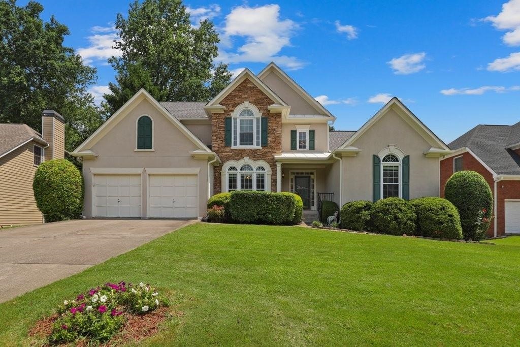 Welcome to this East Cobb charmer nestled in the sought-after community of Grovehurst. Step in and be greeted by the soaring 2 story foyer and gleaming hardwood floors throughout the main floor. The stunning greatroom has a wall of windows to keep things bright and a unique two-sided fireplace that opens to the spacious chef's kitchen. The primary bedroom is on the main floor offering both privacy and convenience. Relax in the large spa bath featuring dual vanities, a soaking tub, and a walk-in shower. Upstairs are 2 more cheerful bedrooms and a full bathroom. The finished basement includes a kitchen, bedroom, and full bath and has endless potential for additional living space. The oversized deck looks out over the fenced backyard, perfect for pets, playsets, and outdoor activities. New paint, lighting, and fixtures throughout! Lovingly maintained and move-in ready. Located in the prestigious Walton High School district and just a short distance to nearby shopping and restaurants. Don't miss the 3D tour and 360 degree view of the exterior.