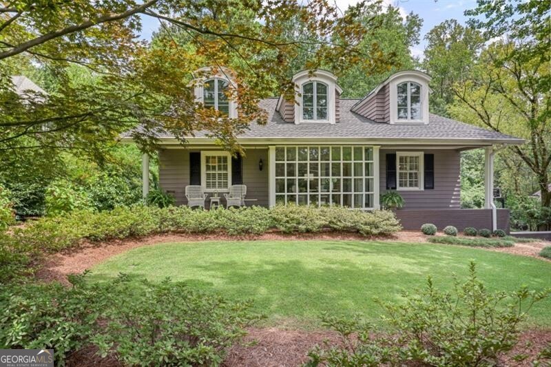 Charming Historic Brookhaven Residence with Carriage House & Timeless Appeal - Perfectly situated near the prestigious Capital City Club, this impeccably maintained home blends classic charm with thoughtful updates from two significant renovations. From the custom bluestone entrance to the lush, landscaped grounds, every detail exudes curb appeal and character. Inside, gleaming hardwood floors flow throughout the main level, complemented by plantation shutters, custom windows, and doors. A light-filled entry opens to a beautiful covered front porch overlooking a flat, private, professionally landscaped yard set well back from the street. The main floor offers multiple gathering spaces, including a formal living room with fireplace, elegant dining room, and cozy family room with its own fireplace. The spacious primary suite features a private deck with serene backyard views, plus an additional bedroom and full bath on the main level. The sunny kitchen with breakfast room leads to a screened porch perfect for enjoying the tranquil, fenced backyard. Upstairs, two generous bedrooms are connected by a versatile study/playroom with new carpet. They share a large, light-filled bath with beautiful tile finishes. The property also boasts a stunning carriage house-perfect as an in-law suite, teen retreat, or private guest quarters-accessible from the screened porch. It offers a large media/den area, dining space, oversized bedroom, and full bath, plus its own generator and private staircase to the garage. The lower level includes four garages, abundant storage, a mudroom, and a laundry room. A charming potting shed is attached to the rear garage, perfect for gardening enthusiasts. Recent updates include a newer roof, security lighting, and cameras. Located in the sought-after Sarah Smith Elementary district, with easy access to Little Nancy Creek Park and Buckhead's premier shopping, dining, and amenities-this home offers the perfect combination of location, livability, and timeless luxury.
