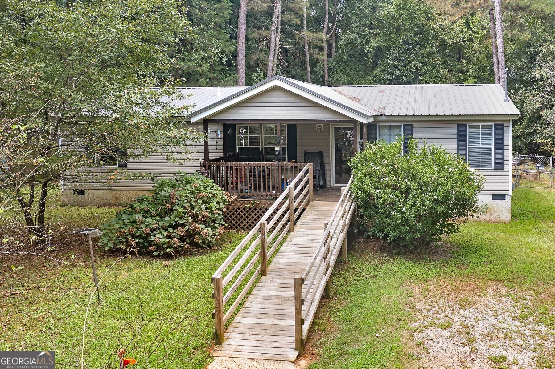 Great wooded lot with private, fenced back yard. Detached garage or shop. Home is Move-in ready and has all kitchen appliances. The split bedroom plan and open floor plan make the home feel like a much larger house. The island/breakfast bar opens the kitchen to the Great room and gives lots of additional counter space. New metal roof-2025, new water heater-2023, Septic service and pumped-2019, Manufactured home title retired-financing possible!! Come see your new home today.