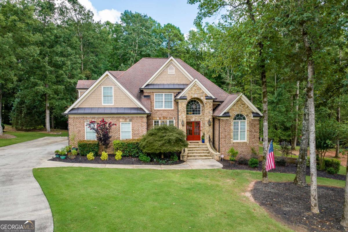 Welcome to 1031 Riverhill Drive, an impeccably maintained and thoughtfully designed home located in the prestigious Lane Creek neighborhood in Oconee County. Nestled on a full one acre lot, this 5-bedroom, 4.5-bathroom home offers the perfect blend of elegance, functionality, and space for modern living. Step inside to find a bright and open main living area featuring beautiful wood floors, a cozy gas fireplace with gas logs included, and an inviting layout ideal for entertaining. The chef's kitchen boasts updated appliances, a large pantry, and flows seamlessly into the living and dining areas. A convenient half bath is located just off the living space. The spacious primary suite is situated on the main level, offering a peaceful retreat with an en-suite bathroom, dual vanities, a soaking tub, and separate shower. Upstairs, you'll find three generously sized bedrooms and two full bathrooms, perfect for family or guests. The mostly finished walk-out basement expands your living space with a large office, a media room, a bedroom and full bath, and a versatile area complete with a kitchenette and full bar-ideal for entertaining, in-laws, or a teen suite. Enjoy outdoor living on the expansive back deck overlooking the private, tree-lined yard-plenty of room for play, gardening, or simply relaxing. The yard backs up to a lush wooded area that leads down to a small creek towards the bottom of the lot. Recent updates include a new water heater, interior paint, finished wood floors and newer HVAC systems and appliances, offering peace of mind and energy efficiency. Zoned for the award-winning North Oconee School District, this home offers the lifestyle and location you've been waiting for. Dont miss out on this one of a kind property in an ideal location!