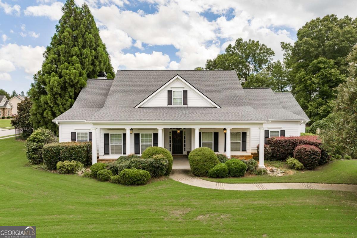 From the moment you step inside, you can feel the care and thought that went into every detail of this custom home. Nearly an acre of green, fenced yard surrounds you, offering privacy and a sense of space that's hard to find. The foyer opens to a bright, open living room where beautiful large windows frame direct views of the backyard. Built-ins surround the cozy fireplace, and rich hardwood floors run throughout the home, adding warmth and continuity. The kitchen is both functional and inviting, with granite countertops, warm travertine tile backsplash, abundant cabinetry, and a generous island that's perfect for gathering. The main-level primary suite is a true retreat with a spa-like bath: soaking tub, walk-in shower, double vanities, and a spacious walk-in closet. Two additional bedrooms and a full bath are also on the main floor, along with a laundry room that features its own puppy shower. Upstairs, a vaulted flex space invites endless possibilities: a family room, game room, or TV lounge - plus a dedicated craft or office/flex space. You'll also find another bedroom with its own full bath, and plenty of storage for everything you want to keep tucked away. Out back, the large deck overlooks a flat, private yard that feels instantly welcoming - perfect for grilling, playing, or simply relaxing at the end of the day. Living in Whitlow Creek means more than just having a beautiful home. You'll enjoy a pool, tennis courts, walking trails, a playground, wide green spaces, a serene pond, and a covered pavilion with fireplace for community gatherings - all in the highly desirable Oconee County School District. Make your appointment to visit this wonderful home today!
