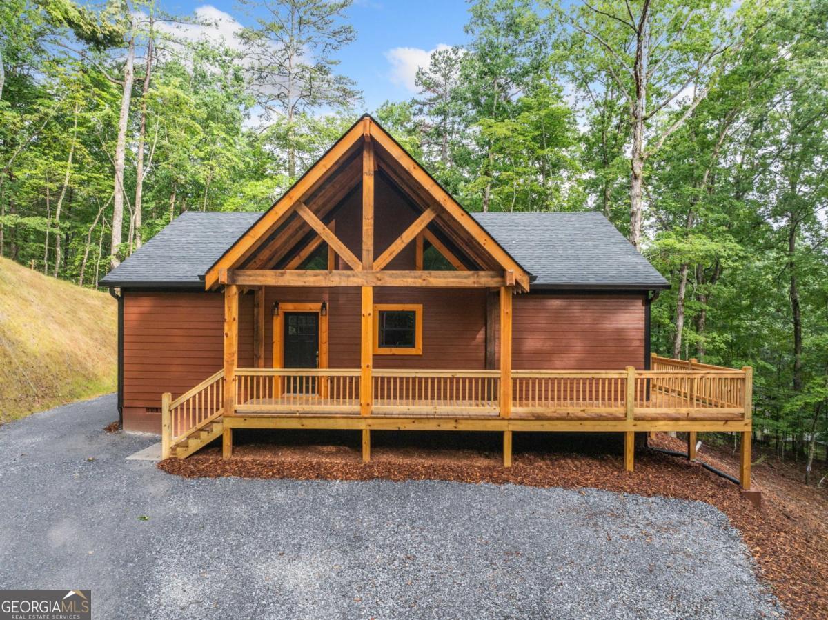 Nestled in a peaceful-private setting this Completed New Construction cabin is ready for you to move in. The open-concept design features a split floor plan, with 2 spacious bedrooms and 2 full bathrooms on the main level. The gourmet kitchen boasts beautiful rough sawn wood cabinetry, granite countertops, and a one-of-a-kind island with seating. New matching stainless steel appliances complete the chef's dream space. The expansive laundry/pantry/mudroom is a must-see! Beautiful tongue-and-groove wood cathedral ceilings with wood accent beams that add warmth and charm throughout the home. The perfect balance of wood and sheetrock walls creates a cozy atmosphere. The impressive stone fireplace with gas logs is the centerpiece of the living area. The large master suite accommodates a king-sized bed and features dual sinks, a luxurious floor-to-ceiling tile shower, and a spacious walk-in closet. High-end flooring throughout offering both beauty and durability. Enjoy outdoor living on the large partially(3/4) wraparound deck. The easy-care Hardie concrete siding and gutters ensure minimal maintenance for years to come. This home is truly a must-see!