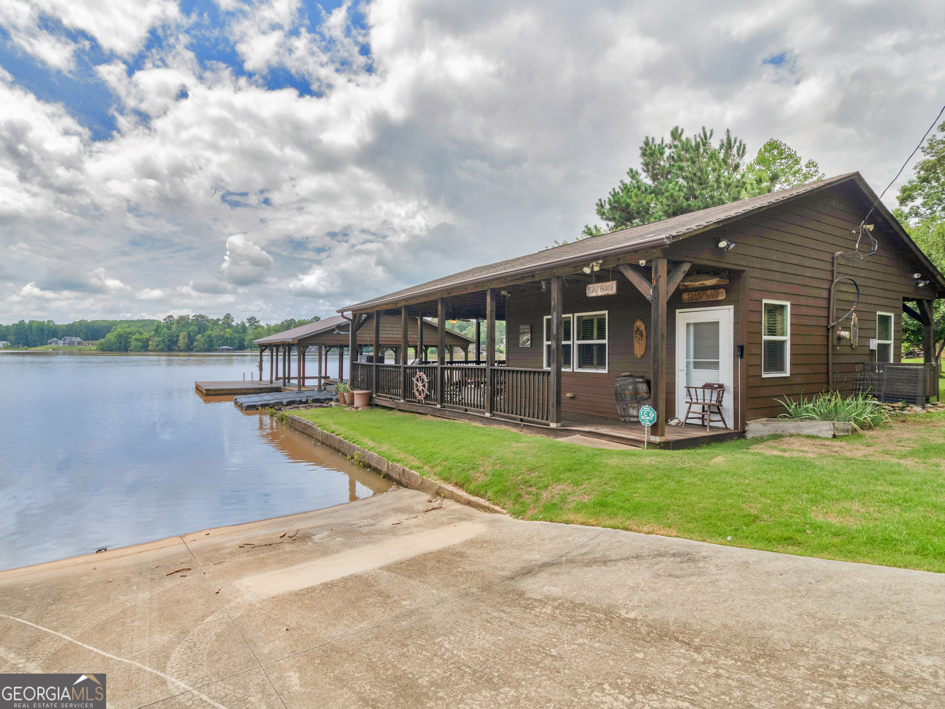 ESCAPE TO YOUR PRIVATE RETREAT! 4.32 Acre DEEDED WATERFRONT property on Jackson Lake. Build your NEW HOME or renovate the existing old house. This property has history! At one time ''In The Heat Of The Night'' was filmed here and also this was formerly Gus's Marina. Currently zoned residential but could possibly be zoned back to Commercial. As you enter the property through the wrought iron gated driveway you will be amazed at all the possibilities with 682 feet on the water. Be sure to see the boat ramp, double boat slip with lift, swim platform and rip rap seawall. Great fishing and amazing views plus so much privacy! The Boat house has a fully equipped updated kitchen, storage room for systems, and an awesome Covered Party Deck and Dock! The Bath house has a full bathroom and storage room large enough for a bedroom plus the wraparound porch. Please Do Not enter the Old House until you're Under Contract with a Due Diligence period and Inspector. See the Catalpa trees, pear and apple trees as well as the blueberry bushes and enjoy the beautiful Zoysia landscape. This land has been loved. Be sure to notice the old Budweiser sign that probably has many stories to tell! Please note this will need to be a cash sale. Talk to Tammy or Jamie for more details and to see Today!