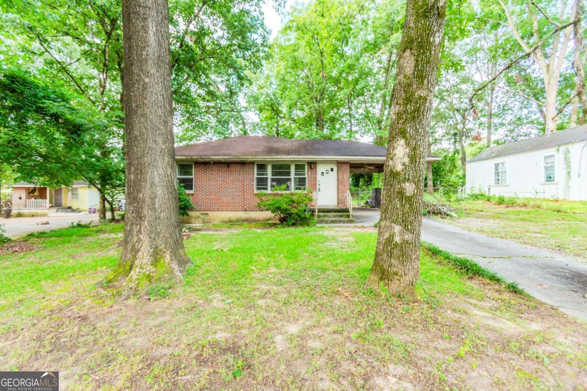 INVESTORS, TAKE NOTICE! Opportunity awaits in the highly sought-after Forest Park neighborhood! This solid 2-bedroom, 1-bath all-brick ranch sits on a beautiful lot and offers endless potential. Built in 1950, it features a spacious living room just off the kitchen-ideal for expanding your living or entertaining space-plus original hardwood floors, a separate kitchen, and a smart, functional layout. Enjoy the benefits of four-sided brick construction, a carport, and a large backyard ready to be transformed into your own private retreat. Located minutes from I-75, I-85, I-285, downtown Atlanta, and Hartsfield-Jackson Airport, with quick access to top dining, shopping, and parks. With great bones and a prime location, this home is perfect for a fix-and-flip or rental portfolio addition. Just bring your vision-TLC will go a long way!