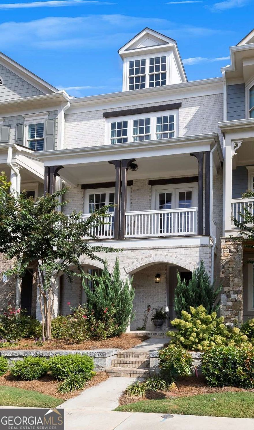 Stunning townhome located in the highly sought-after South on Main community in the heart of Downtown Woodstock. This popular Andrews floorplan offers three levels of beautifully designed living space. The entry level welcomes you with an inviting foyer that leads to a private bedroom with a charming barn door and full bath-perfect for guests or a quiet home office. The rear-entry two-car garage opens into a convenient drop zone for everyday ease. The main level is filled with natural light and features a spacious family room with a cozy fireplace, built-in shelving, and access to a front balcony-an ideal spot for your morning coffee. The open layout flows seamlessly into the dining room, creating the perfect setting for entertaining. At the heart of the home is a chef's kitchen complete with floor-to-ceiling white cabinetry, a large center island with seating, and a breakfast area with access to the rear deck for grilling. A keeping room with beamed ceilings provides a warm and relaxing retreat, while a guest powder room completes this level. Upstairs, the owner's suite is a private retreat with a large walk-in closet and a luxurious spa bath featuring double vanities, a soaking tub, and an oversized walk-in shower. A spacious secondary bedroom with a private ensuite bath and a laundry room with cabinets and sink provide both comfort and convenience. This home is elevator-ready, with the shaft offering the flexibility to install an elevator in the future or enjoy the impressive additional space as extra storage or a functional office nook. Life at South on Main is truly exceptional. This premier community spans 20 acres of green space and parks, offering a community garden, firepit, resort-style swimming pool with splash pad and cabana, and a 6,000-square-foot clubhouse with fitness center, game room, and conference space. Residents also enjoy two dog parks, a play park, an open-air pavilion, "The SHED" stage for live events, and direct access to the Noonday Creek Trail, part of the expansive Greenprints system. All of this is just steps from the vibrant energy of Downtown Woodstock and minutes from I-575, making for an easy commute to Atlanta and beyond. Experience why South on Main and Woodstock are among North Georgia's most sought-after destinations-this home offers the perfect blend of style, comfort, and lifestyle.