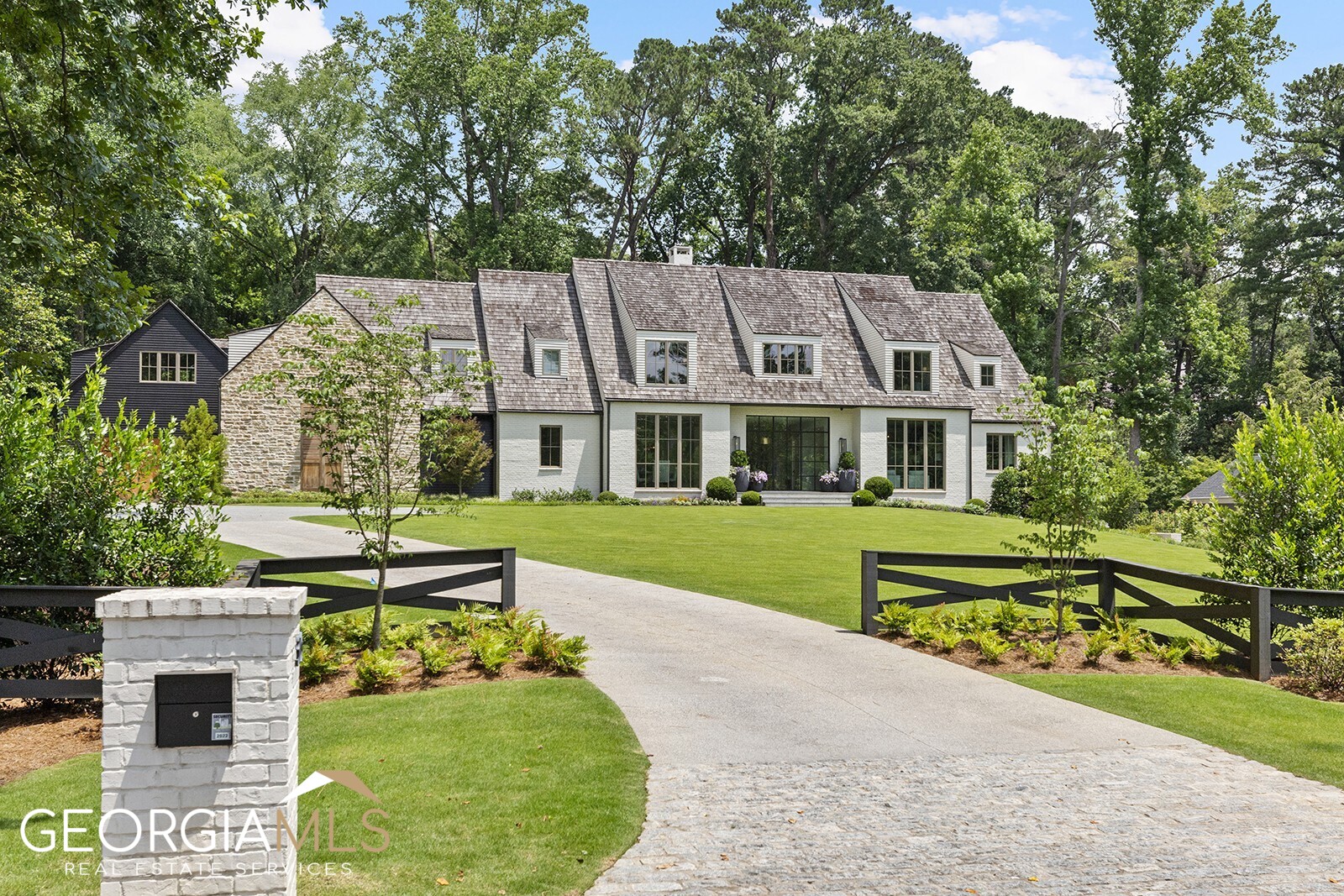 Offering the highest level of quality and design excellence, this striking transitional modern home built by Siegel Construction and Design  sets a new standard of luxury in Chastain Park oriented on 1.5 acres. Floor-to-ceiling windows flood the open main level with natural light creating a seamless integration of indoor and outdoor living. Designer light fixtures, exposed wood beams, white oak floors, custom wall treatments and impressive iron doors and windows are among the many carefully curated design elements that contribute to the home's enduring appeal. A stunning eat-in kitchen with marble counters, bespoke ceiling-height cabinetry and a suite of premium appliances overlooks the adjoining great room, fireside covered porch and backyard pool area with automated pool cover. The spacious main-level primary suite features a lavish spa-inspired bath with dual floating vanities, spacious shower, separate soaking tub, heated marble floors and oversized walk-in closet and dressing area. Upper level offers 5 en-suite bedrooms, a convenient flex room, study/craft room and laundry. The daylight terrace level features a home gym, golf simulator, entertainment room, private guest suite with shower and outdoor patio.  Other noteworthy features include a 800-900 bottle wine room, whole house generator, Control 4 smart home equipment, and remarkable fenced walk out flat backyard.