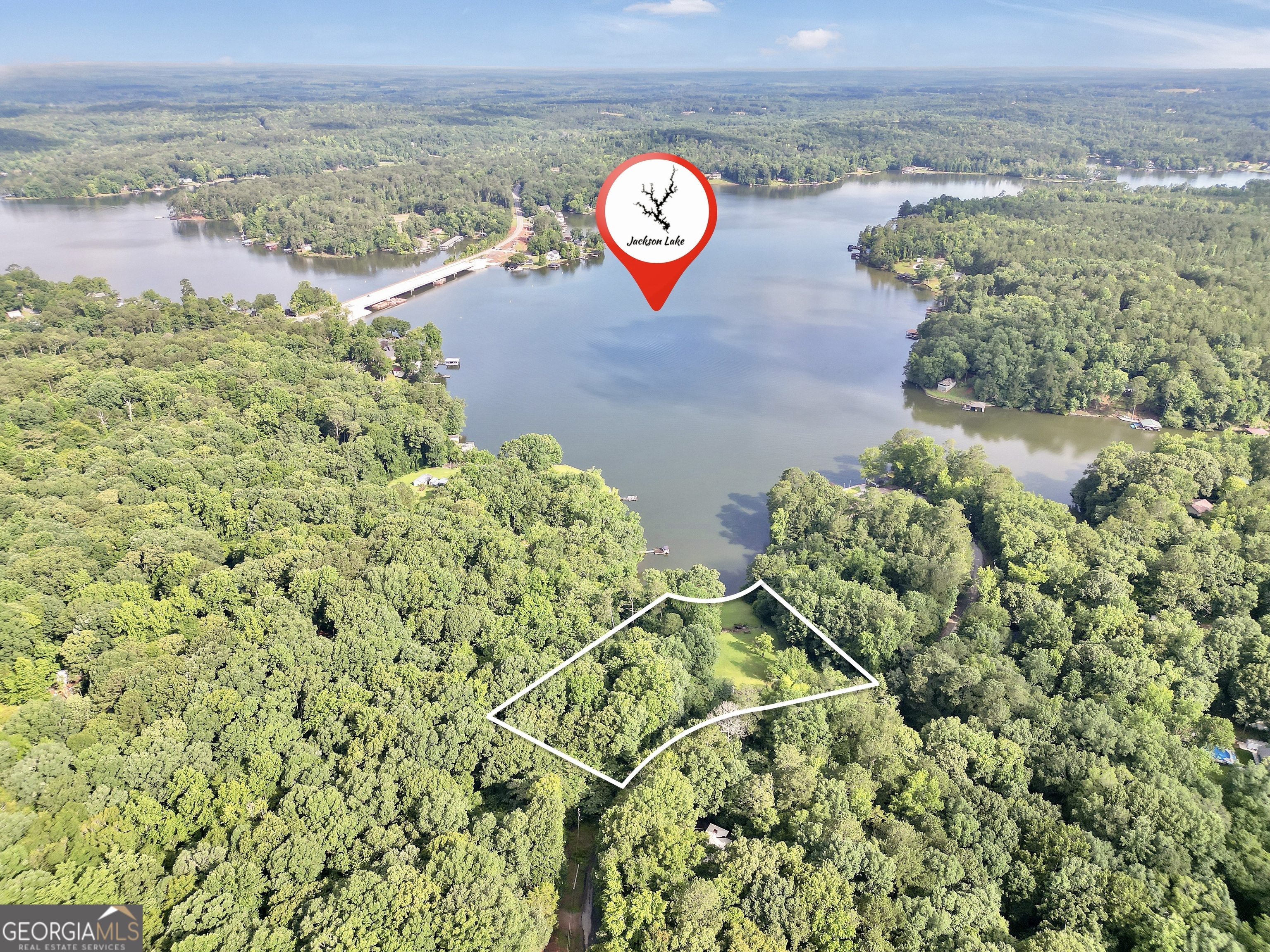 Escape to your private waterfront oasis on the beautiful shores of Jackson Lake. This 2+ acre deeded lakefront lot is situated in a cove with approximately 160ft of water frontage just east of the 212 bridge, offering both stunning views and deep water. With a two-slip covered boat dock with power lifts already in place, you'll be able to start enjoying the lake life immediately. In addition, there are both 30amp & 50amp RV hook-ups; a storage shed with water, electricity & fiber internet already in place; and a gated entrance. Call today for more information & to make an appointment to see this property for yourself.