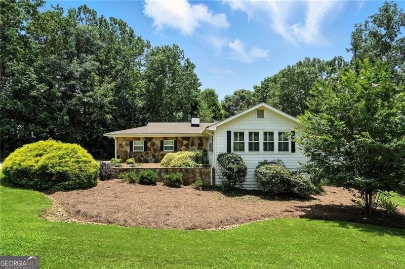 Sought after Thompson Road, this updated and charming ranch sits on a one acre level lot. The flowing and open floor plan provides numerous options for the living spaces. The redone kitchen features a large center island with granite counters. The family chef will enjoy the new stainless appliances, the abundant counter and storage space as well as the oversized pantry. Custom cabinets have spice pull outs flanking the stove. Cook while enjoying the open space to the keeping and great rooms, or while enjoying the warmth of the stove insert in the wood burning fireplace. Plantation shutters adorn the newer double paned windows throughout the home. The front sitting room is an inviting space to gather, wonderful natural light and tons of space; this is a peaceful gathering spot. Separate from the living spaces the bedrooms offer privacy from the living spaces. The primary bedroom features a large walk-in closet, an updated bathroom with a jacuzzi tub. Two secondary bedrooms share the hall bathroom. On the terrace level you will find two finished rooms, one with a full bath. Plenty of storage or space to finish if needed. Outside you will find a detached barn/garage: this space is currently used as a workshop. The functioning new garage door on the barn/garage also provides extra housed parking if you need a 3rd space. Newer HVAC, water heater. 4 year old roof, new concrete plank siding. This location cannot be beat: close to the top-ranked Milton schools, downtown Alpharetta, Bell Memorial Park. PRICED to SELL!