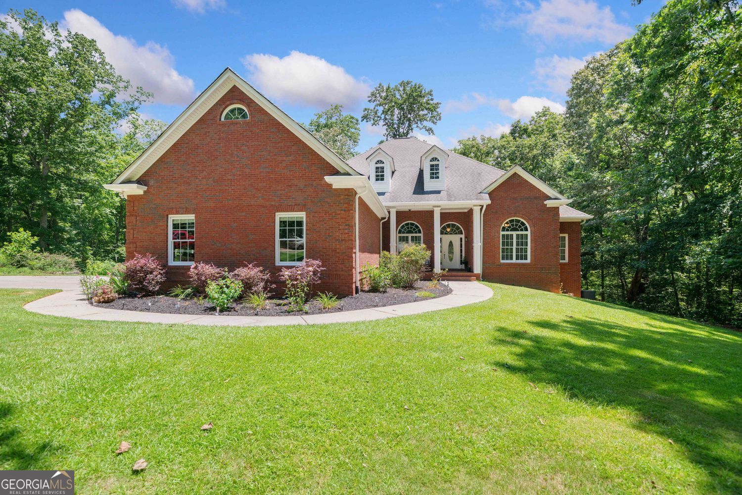 RARE FIND!!! Welcome to your Dream Home in desirable Clayton Community!! This all brick, custom ranch home with a full basement sits on 3.26 acres, offers the perfect blend of privacy and convenience. Full finished basement provides additional living space, including a home theater, game room, bedroom and two full baths. Also an additional oversized garage with room with 2 additional cars and a workshop. This open concept ranch has an large kitchen with granite counters and upgraded appliances with double convection ovens, oversized walk in pantry, and a view to the family room over a large, raised breakfast bar. It is great for entertaining. the separate dining room and separate living/office are great additional spaces on the main level. The oversized primary suite on the main has room for a sitting area, cathedral ceilings, and a spa bath. The split bedroom plan offers 3 additional secondary bedrooms on the main. The large deck off the back looks over the private backyard that does include a creek on the property. This property is not in a subdivision and does not have an HOA. The 3-car garage on the main level ensures plenty of parking and storage for your vehicles and equipment. Despite its private, open setting, the home is conveniently located near restaurants, shopping, and major highways (I-515 and I-575), Makes it centrally located for Canton, Jasper, Ball Ground, and all the major highways. This beautiful home is a rare find and has endless possibilities while offering maintenance free 4 sided brick!! Don't miss the opportunity to make this beautiful home yours!