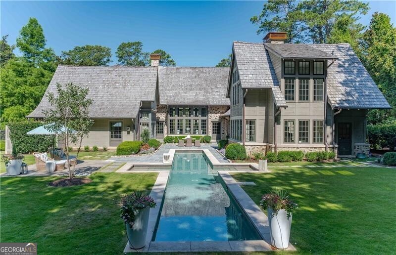 An English inspired masterpiece thoughtfully designed by architect Bobby McAlpine and Builder Shaba Derazi brings a feeling of historic charm to Buckhead. Truly no details have been left untouched in the oak floors, pecky cypress accents & limestone fireplaces. Light filled entrance foyer leads to breathtaking living room and dining room. Chef's kitchen that opens to the keeping room offers stunning wood details, oversized island and Wolf/Subzero appliances. Sought after primary suite on main hosts dual dressing areas and spa-like primary bath as well as adjoining study. The primary bath offers dual vanities, dual shower and dual water closets as well as heated floors. The manicured grounds are reminiscent of the English countryside with pool, level backyard and lush garden area on over an acre of land. The property also consists of a free standing cottage used as a pool house as well as a detached two car garage with finished space above as a guest suite. The property has geo-thermal heating and air systems and private well water serving the pool, irrigation system and home. Truly a special home on a coveted Buckhead street!