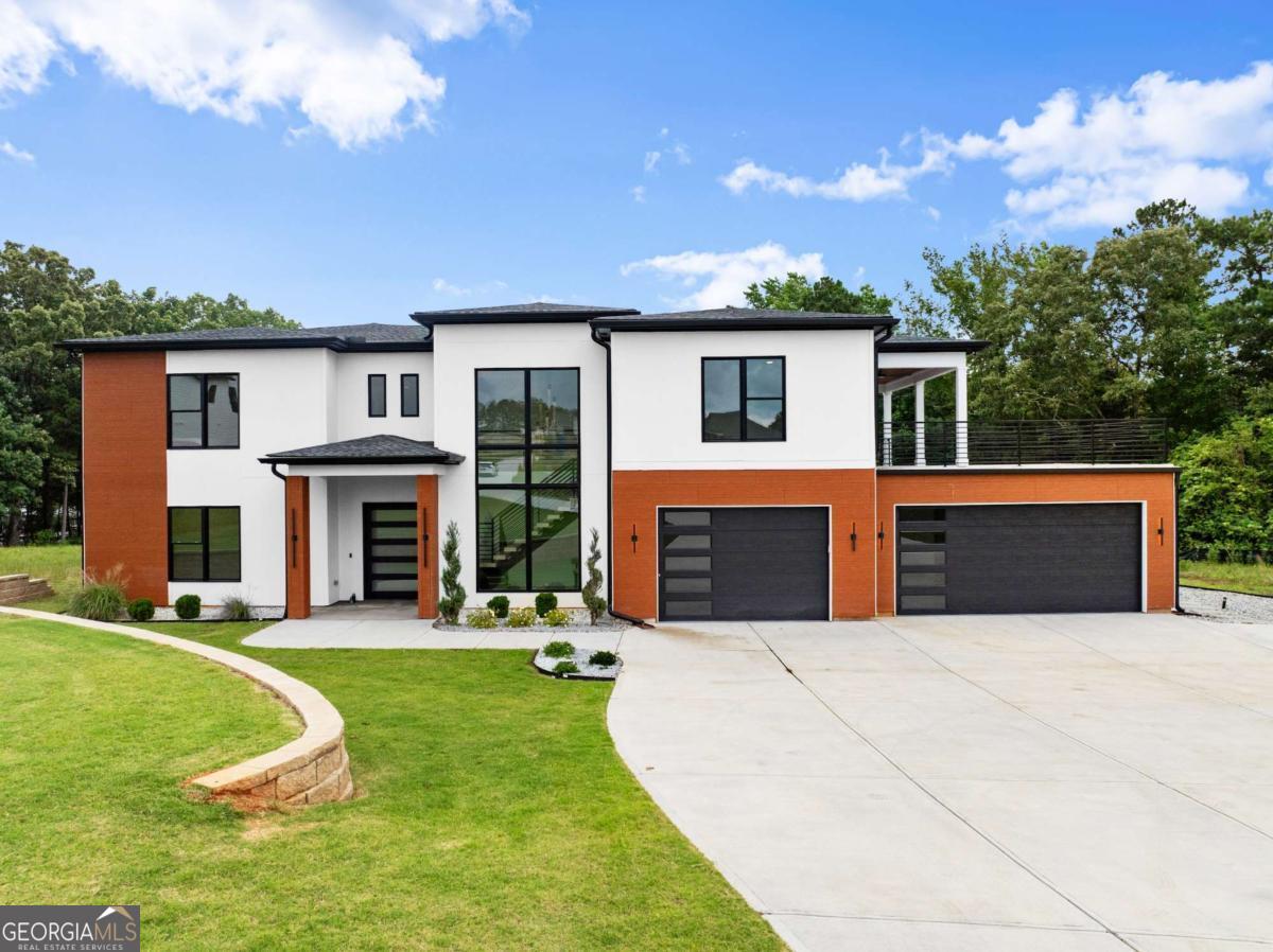Introducing the stunning modern house plan Featuring 4 Bedroom, 4.5 Baths with Master on Main with a Harmonious blend of contemporary design and timeless elegance. Upon entering, you are greeted by a grand floating staircase, a true centerpiece that commands attention and invites you into the heart of the home. Towering windows adorn the walls, stretching from the floor to the ceiling, flooding the interior with abundant natural light and offering breathtaking views of the surrounding landscape. The main floor is designed with both practicality and entertainment in mind. An office provides a private sanctuary for work or study, while the open-concept layout seamlessly connects the kitchen, dining area, and great room. Kitchen Features Ginormous Island, Commercial Grade Appliances including built in 60' Fridge, Hidden Butler Pantry with Appliance and Coffee Bar inside. The great room is a soaring space, with its double-height ceiling with Electric Fireplace featuring Accent Trim and Floating Shelves on each side creating an atmosphere of openness and spaciousness, perfect for gatherings and creating cherished memories. Tucked away on the main floor, the luxurious master suite with Fantastic View of Lake is a haven of tranquility. It boasts a spa like bathroom with not one but three shower heads and soaking tub, providing a serene retreat for relaxation and rejuvenation. A walk-in closet with Island built in for convenience. Mudroom provides a practical transition space from the 3- car garage to home. Ascending to the second floor, you'll discover three Oversized-sized bedrooms and flex room, each accompanied by its own walk-in closet, ensuring ample storage space for personal belongings. From this level, access to the Partially Covered Roof Top deck is granted, providing a versatile outdoor space for entertaining or simply enjoying the beauty of the Lake. Beyond the Roof Top deck, a hidden gem awaits in the form of a loft area with Private Bedroom and Bath for Guest. This versatile space features a wet bar, allowing for effortless hosting and serving. French Iron doors open up to Theater Room Featuring 4K Laser Projection, 120' HD Screen, 7.1 surround sound controlled by a state-of-the-art control4 automation system. Enjoy your morning coffee on lower-level covered patio with view of lake from all sides. Home Features Black Out Blinds with Automatic Remote in Master. Subdivision features Golf Cart Path to Community dock with electricity. Slip 10 is deeded with property. Close to Shopping and Dining. Hartwell is a truly remarkable living experience.