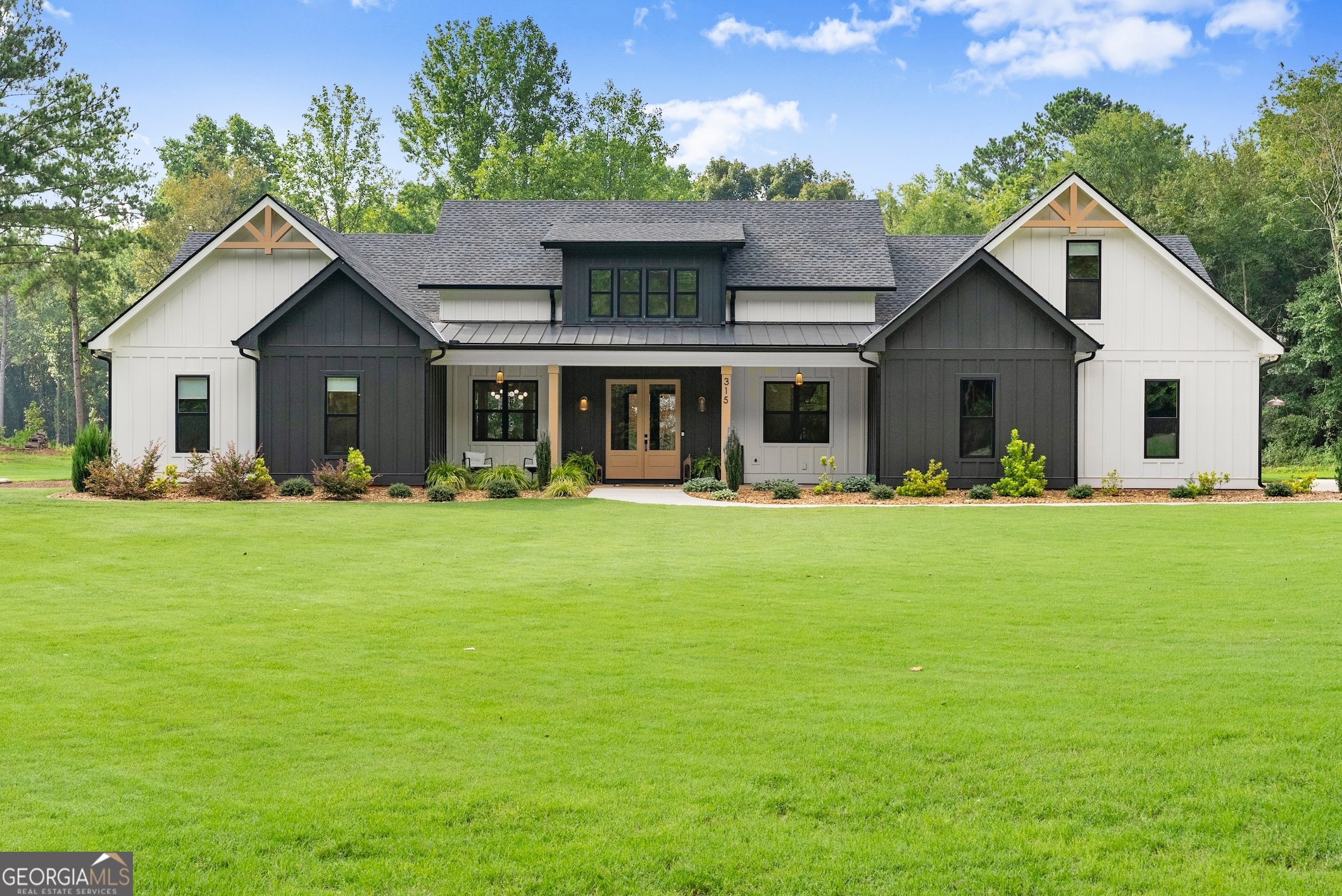 Welcome to your dream home! Nestled on a quiet country road, this custom-built modern farmhouse offers the perfect blend of upscale design, privacy, and space-set on a beautifully level 3-acre lot, ideal for peaceful living or entertaining. Step into the grand, inviting foyer and take in the attention to detail throughout. The gourmet kitchen is a chef's dream, featuring stunning quartz countertops, an 8-burner gas stove with pot filler, stainless steel appliances, a huge island with seating for six, and custom tilework under tongue-and-groove ceilings. A one-of-a-kind walk-in pantry with cabinets, a coffee bar, and abundant storage takes functionality to the next level. The spacious family room centers around a beautiful stone fireplace with gas logs, high ceilings, and large windows that flood the space with natural light. The luxurious master suite boasts a designer accent wall and vaulted ceilings, leading to a spa-like master bath with tiled floors, double quartz vanities, an extra makeup vanity, and a double tiled shower with frameless glass door. The master walk-in closet connects conveniently to an oversized laundry room. Three additional bedrooms are located on the main level, with a large bonus/bedroom suite upstairs complete with a full bath-perfect for guests or a private office. Enjoy quiet evenings or weekend gatherings on the expansive covered back porch, featuring tongue-and-groove ceilings, recessed lighting, and ceiling fans. The level backyard is pool-ready and completely private, offering endless possibilities. Don't miss this rare opportunity to own a stunning, move-in-ready farmhouse just two years young. Schedule your private showing today!