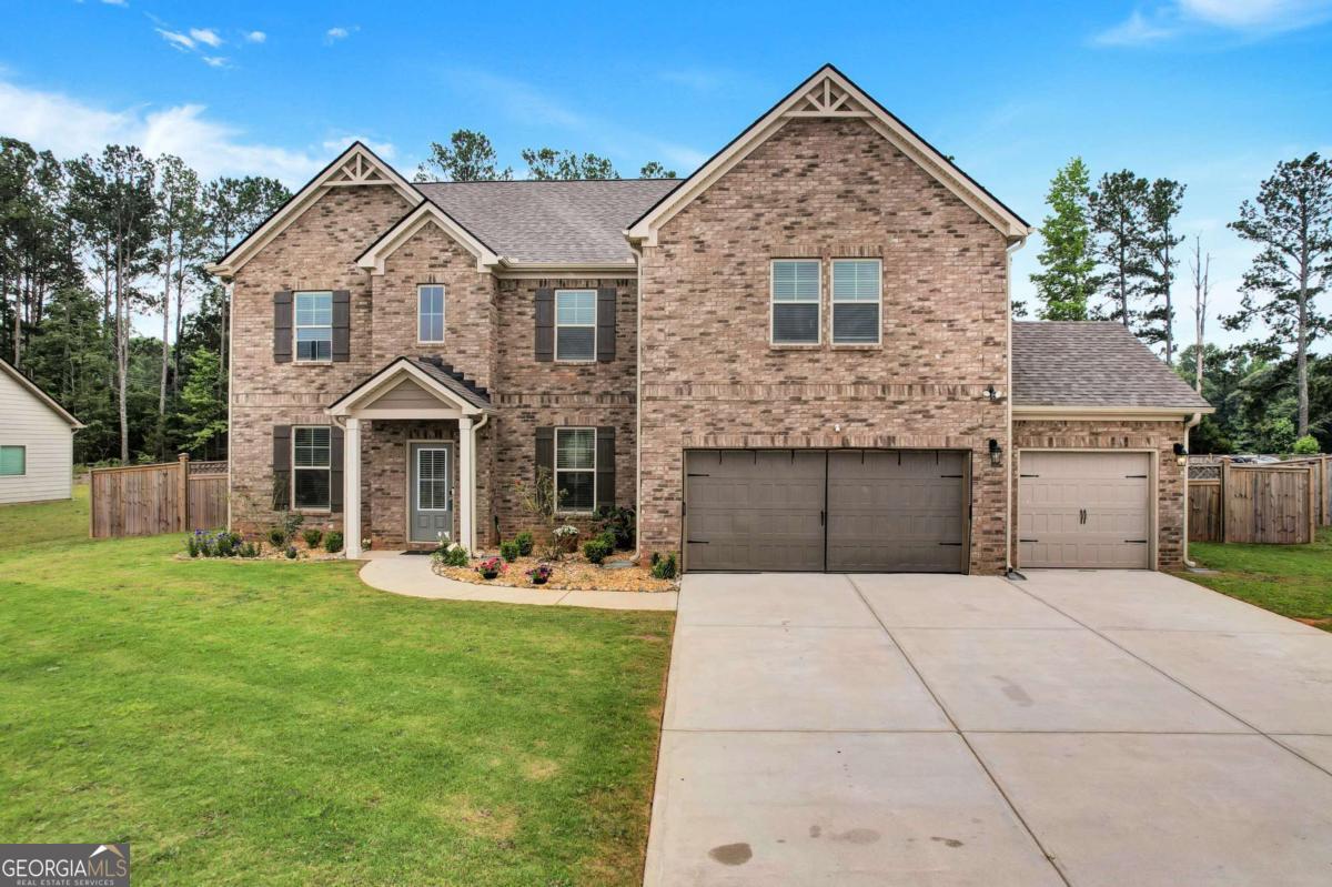 Step into luxury living with a spacious and beautifully designed home in the highly sought-after Flakes Mill subdivision of Henry County. Featuring a 3-car garage, this stunning residence offers 3,856 sq ft, 5 generously sized bedrooms and 4 full bathrooms, making it ideal for growing families or those who love to entertain. With a Chef's Dream Kitchen, prepare to be inspired by the gourmet kitchen featuring quartz countertops, farmer's sink, stainless steel appliances, double oven, custom tile backsplash, and an expansive walk-in pantry. The open-concept layout seamlessly connects the kitchen to the family room with a cozy fireplace, perfect for family gatherings and hosting. The main floor includes a spacious guest bedroom or study, a formal dining room with elegant coffered ceilings, crown molding, and shadow box trim, plus a separate formal living room. Upstairs, enjoy quality time in the open loft overlooking the foyer. The Owner's Suite is a luxurious retreat with a sitting area, double-door entry, and a spa-inspired bath featuring a separate shower, water closet, and a huge walk-in closet. Three additional oversized secondary bedrooms include access to a Jack & Jill full bath. Laundry is conveniently located on the upper level. Relax or entertain in the fenced backyard, complete with a huge shed for extra storage. Nestled in the beautiful and quiet Flakes Mill neighborhood, you're close to top schools, parks, shopping, and major commuting routes.
