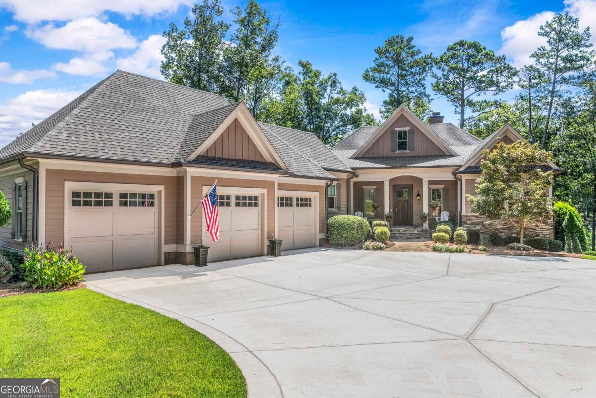 STUNNING CUSTOM SINGLE FAMILY HOME NESTLED ON A QUIET CUL DE SAC WITH VIEWS OF ANGEL POND, MODERN UPGRADES, AND PRIME LOCATION IN REYNOLDS. Located on Angel Pond with access to extensive walking trail and incredible water views, this updated, move-in ready 3 bedroom, 3.5 bath home with a three car-garage in Reynolds Lake Oconee offers high end finishes, spacious living, and a functional layout designed for everyday comfort. With 10' ceilings on both levels, the home features custom upgrades throughout and is minutes from the security entrance, Publix, Creek Club, Lake Club and Ritz Carlton. Step inside a light filled main level designed with open floor plan for everyday living and entertaining. A vaulted great room anchors the space, featuring a stone fireplace, custom drapes, and 16' sliding doors that open to a full length composite deck overlooking the water. The adjacent kitchen is outfitted with an 8' custom island, paneled refrigerator and dishwasher, and a walk in pantry with built in shelving. Flowing directly into the dining area, this central space creates a natural gathering point with pond views as the backdrop. Privately positioned on the main level, the primary suite offers direct deck access, two custom walk in closets, and an en suite bath with dual vanities, a jetted soaking tub, and a spa style shower. A powder room, laundry room with storage and office nook complete the main floor. The terrace level extends the living space with a large family room centered around a fireplace and a custom bar with built in refrigerator and dishwasher. One en-suite bedroom features a walk in closet, while a third bedroom and additional full bath offer flexibility for visiting guests. Step outside to a flagstone patio that runs the full length of the home, continuing the water facing design. Additional features include custom blinds throughout, reverse osmosis water purification, StreamLabs remote water monitoring, and professionally enhanced landscaping. Located near the Hwy 44 security gate for quick access to community amenities. Membership available.