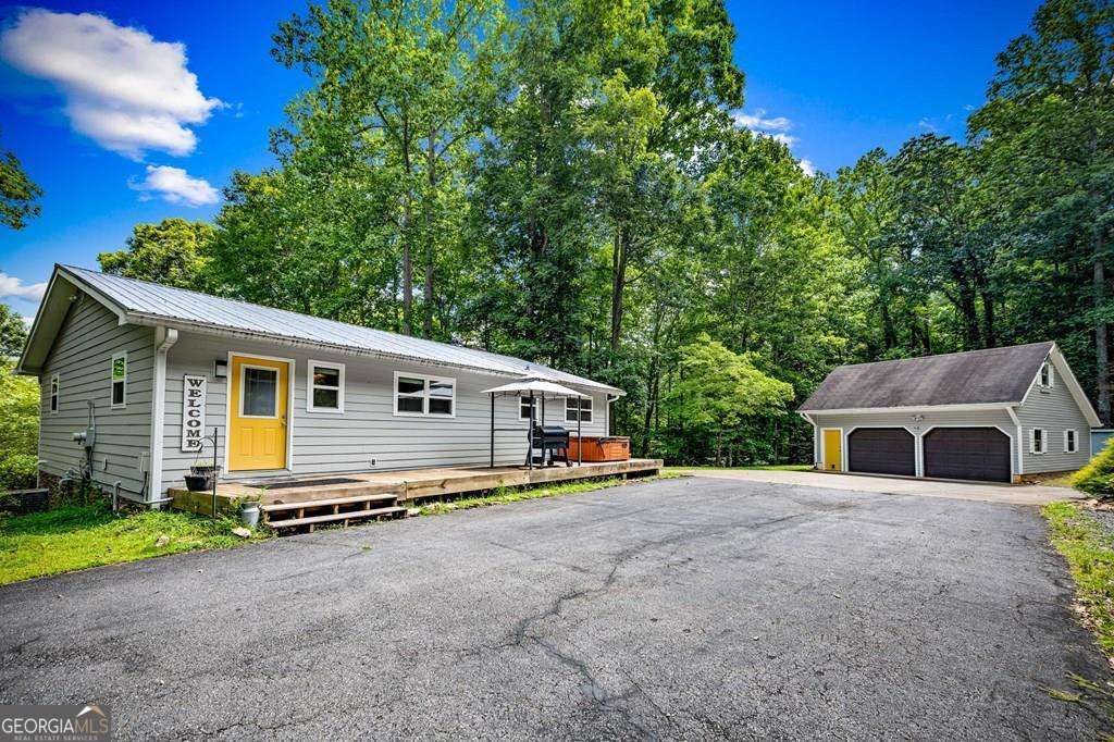 Charming Cottage Retreat with Privacy! Tucked away in a serene, private setting just minutes from town, this inviting 3 Bedroom, 3 Bath one-level home offers the perfect blend of comfort and convenience. The spacious, open layout is filled with natural light and features newly updated flooring in the kitchen, dining room, family room, and hallway-adding a fresh, modern touch. A brand-new tankless gas water heater ensures energy-efficient comfort year-round. Step outside to enjoy your peaceful surroundings-this property borders US Forest Service land, offering direct access to nature right in your backyard. A detached 2-car garage provides ample storage and includes space ideal for a guest apartment or studio. New fencing adds to the functionality and charm of this well-maintained property. Whether you're seeking a full-time residence or a relaxing mountain getaway, this one checks all the boxes!