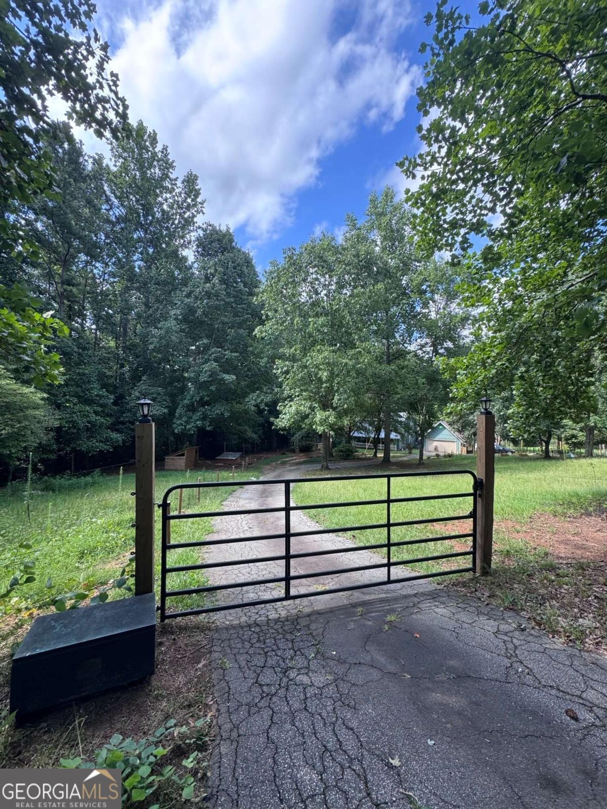 The mini-farm life awaits you in Loganville! This 1.5 acre property is loaded with character! From the moment you drive through the gate you will be greeted by a long driveway leading to the huge detached garage and inviting metal-roofed farm house with a large covered front porch. The home is flanked by 4 different penned areas (currently housing pigs, chickens, dogs and goats); the entire property is secured by electric fencing and backs up to a low lying creek. Inside the home you will be welcomed with gorgeous hardwood floors and wooden ceilings, a cozy yet open floor plan and gorgeous fireplace with wood burning stove in the living room. The oversized kitchen features butcher block countertops with a view to the sun room. Upstairs is an open, multi-purpose loft area, the primary suite with 2 walk-in closets and cozy bathroom, a secondary bedroom and full bathroom/laundry room combo and as an added bonus, the HVAC system is BRAND NEW! The large yard invites endless opportunities to give your "green thumb" a try or just to escape in your s/he shed (or workshop). This is a very unique property looking for new owners to love and care for it and make their dreams come true.