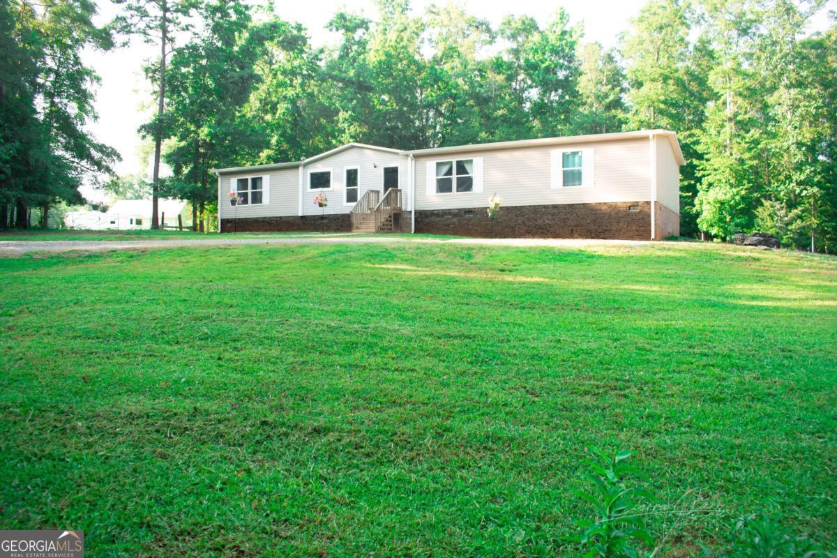 **Showings will start Aug 15, 2025** Welcome to 163 Chappell Mill Rd in charming Milner, GA - a serene 4 bedroom, 2 bathroom manufactured home nestled on a beautiful mini farm. This peaceful oasis sits well off the road, offering privacy and tranquility surrounded by nature. Enjoy the soothing sounds of a creek that runs along the back of the property, creating the perfect country escape. The land is a mix of open space and wooded views, ideal for gardening, raising animals, or simply relaxing. Equipped with its own well and septic system, this property is ready for your self-sufficient lifestyle. Don't miss your chance to own a little slice of country paradise!