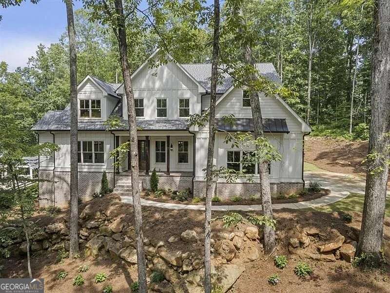 TO BE BUILT - Silver Oaks Luxury Estate with Pool & Spa on 1.87 Acres Brought to you by Larkin Design and Build, one of North Atlanta's most highly regarded builders, the Silver Oaks plan is a 3,836 sq ft two-story residence designed with both elegance and function in mind. Photos shown are of the same plan previously built by the builder, exemplifying the artistry and refined finishes expected in this estate. Built on a slab with optional daylight basement, this home also includes a private main-level walk-out pool and spa. The exterior balances modern farmhouse character with timeless architectural details, leading into a dramatic two-story family room filled with natural light from expansive windows overlooking the pool. The open plan connects the family room, dining area, and chef's kitchen, where a large center island, custom cabinetry, premium appliances, and a walk-in pantry create both beauty and practicality. The main-level owner's suite serves as a luxurious retreat with spa-style bath featuring dual vanities, a soaking tub, oversized walk-in shower, and a custom closet. A secondary bedroom or executive office with full bath access is also located on the main floor. Upstairs, three additional bedrooms and two baths are complemented by a spacious media room and an open gallery overlooking the family room below-perfect for gathering and entertaining. Outdoor living takes center stage with a covered patio, fireplace, and summer kitchen that flow directly to the pool and spa, offering a seamless indoor-outdoor lifestyle. As with every Larkin Design and Build project, buyers may tailor finishes through the design team or adapt the plan to their vision. This estate sits on a 1.87-acre lot only minutes from Downtown Woodstock, Downtown Crabapple/Milton, Alpharetta, Avalon, and Historic Roswell. Everyday conveniences abound with Hickory Flat Village nearby, while golf enthusiasts will appreciate proximity to White Columns Golf & Country Club and Atlanta National Golf Club. Outdoor adventures await at Lake Allatoona and nearby trails, and families enjoy access to top-rated Cherokee County schools, with commuter routes to GA-400 and I-575 close at hand. Completion is estimated within 8-12 months. An adjacent 1.87-acre lot is also available, offering the flexibility of building either the Ranch plan or Silver Oaks, both designed with distinction by Larkin Design and Build.