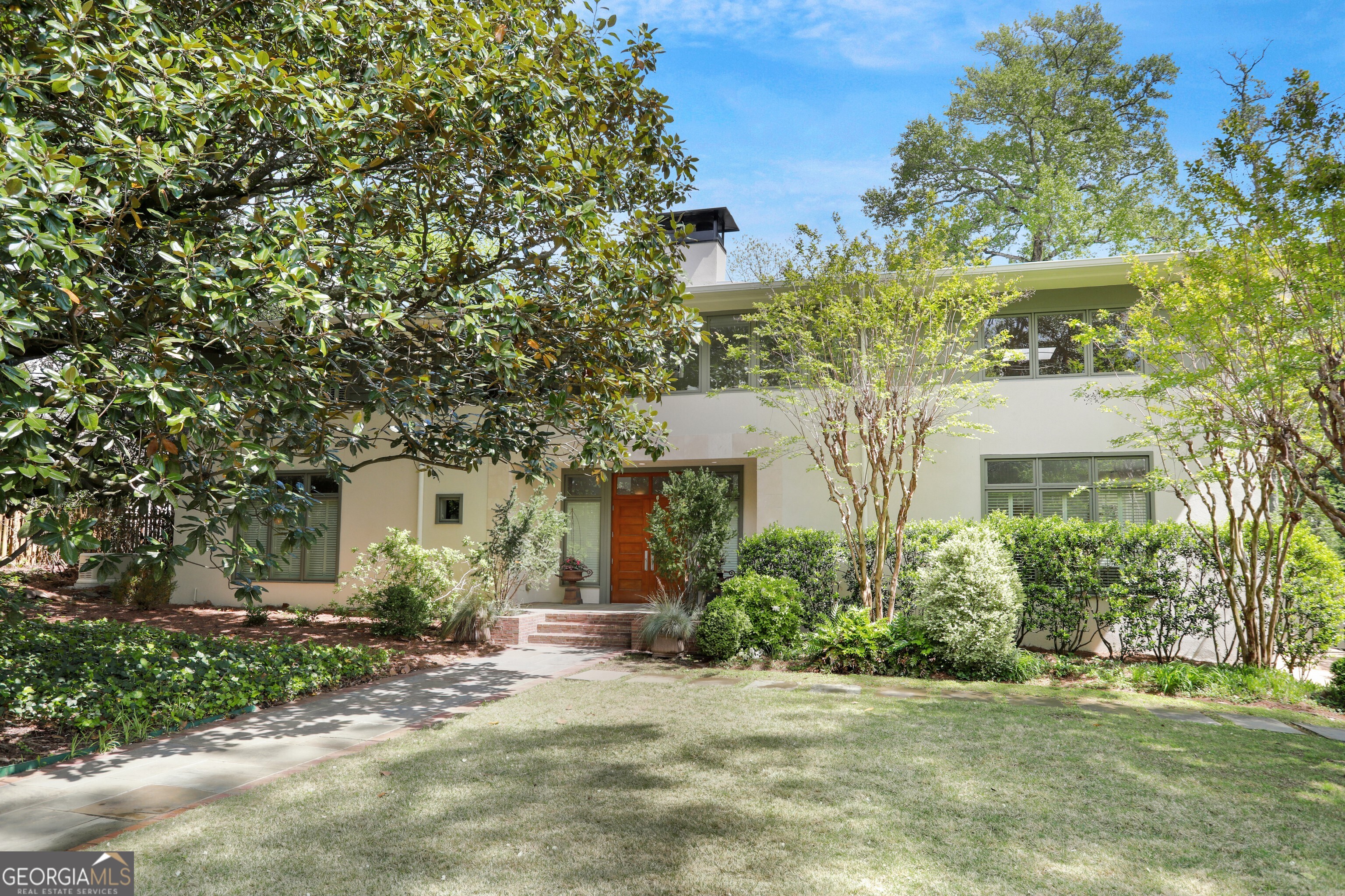 A wonderful opportunity to own a beautiful Modern/Scandinavian style home with a low maintenance yard and LOW DEKALB UNINCORPORATED TAXES in Druid Hills! DRUID HILLS is one of the most sought after neighborhoods in the city of Atlanta. Frederick Law Olmsted, the renowned architect who helped to design Central Park in New York City, Prospect Park in Brooklyn and our own Piedmont Park here in Atlanta, also helped to plan the gracious residential neighborhood and surrounding linear parks called Druid Hills. Known for the wide tree lined streets with sidewalks for walkability to The Paideia School, Emory Village, Emory University and the Druid Hills Golf Club; this historic neighborhood is a community that feels neighborly and connected, yet is convenient to everything urban Atlanta has to offer; including a short half hour drive to the Atlanta International Airports. With mostly historic homes, 1211 Oakdale Road offers a rare opportunity to own a modern home on a prime street in Druid Hills. Built new in 2000 with Prairie Modern influences such as white walls combined with sleek natural woods, this home offers a light filled open floor plan that is at once modern and yet serene and relaxing. A stunning backdrop for your art collection. A renovation and refresh from top to bottom was just completed, which makes this an even more rare opportunity to move in and enjoy a Druid Hills home without the need for further renovation. Although one could implement their own ideas for the space to suit their personal needs. The two story great room looks out over a stone terrace and garden that feels incredibly inviting and offers beautiful views through the glass doors and high windows all along the rear of the home. The brand new kitchen opens to the great room and includes custom made White Oak cabinetry, stone counters, Sub Zero Refrigeration/Freezer and 100 bottle wine cooler, a sleek minimalist Wolf cooktop & a Thermador oven. The home also has a two car attached garage for easy access to the kitchen when arriving home from the market. Adjoining the main entrance hall there is a magnificent glass enclosed custom-built Alder wood 600 bottle wine cellar. Located for easy access while entertaining, it also creates a beautiful display of your wine collection. On one end of the main hall there is a sunny sitting room or separate dining room, and on the other a maple paneled Music room/library/guest room or office and a powder room. There is also a tranquil guest suite with full bath on the main floor with views of the terrace garden. The second floor includes a primary suite with beautiful views of the garden from the bedroom, a new Turkish marble bath with views of the Magnolia branches, custom maple cabinetry and two walk in closets. There are also two secondary spaces and a full bath between in a separate wing upstairs with a full laundry room, an open air balcony, wet bar and a private back stair to the main floor. One of the upstairs rooms is quite large and could be a large den or home office. Both could be bedrooms. In addition to the interior improvements, this hard coat stucco home has a totally re-painted exterior, and a brand new top of the line home generator so that your wine collection and refrigerated items are protected during a power outage and heating/cooling of the home is maintained.