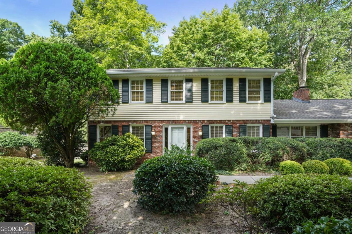 Welcome to this traditional Dunwoody gem nestled in the coveted Windhaven neighborhood! On the main level is a separate living room and a formal dining room, both with hardwood floors. The family room features a brick fireplace flanked by built-ins. The bright kitchen boasts granite countertops, white cabinetry, stainless steel appliances, and a cheerful breakfast area with views of the backyard. A convenient main-level bedroom offers flexibility for guests or a home office. You'll find the primary bedroom on the upper level with 2 additional bedrooms. Step outside to a large stone patio that opens to a private, flat backyard, perfect for play, gardening, or pets. Incredible location! Just minutes from Dunwoody Village, the JCC, Brook Run Park, top-rated schools, local swim/tennis clubs, and easy access to 285/400, this home combines comfort, convenience, and community. No Seller's Disclosure.