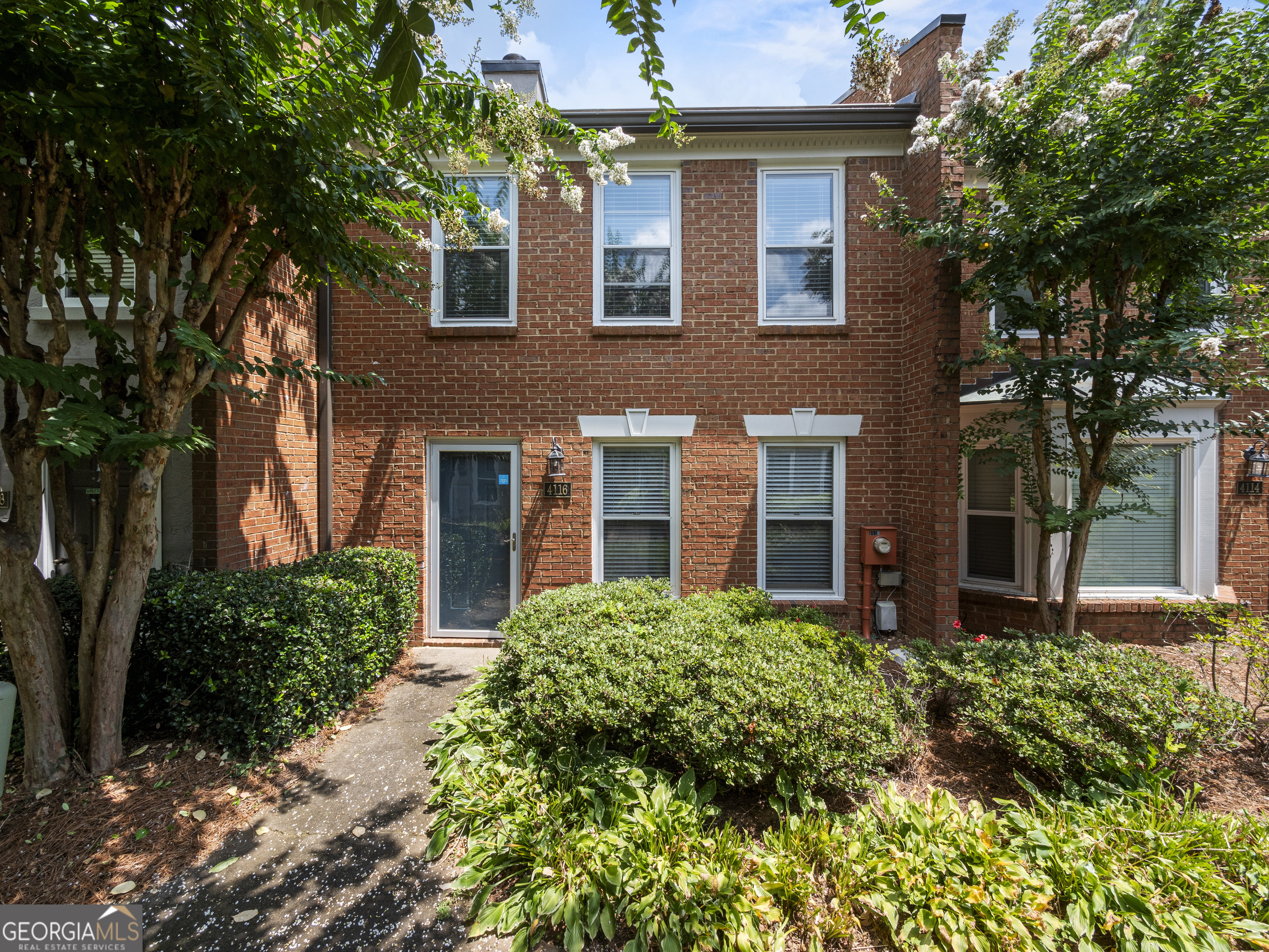 Charming Brick Townhome in Prime Duluth Location - This home offers convenience, comfort, and all the amenities! Fresh paint throughout. Spacious family room with a fireplace flows into a dining area and updated kitchen with stainless steel appliances, granite countertops and a breakfast bar. Upstairs you'll find two generous size bedrooms with large closets and ensuite bathrooms. Enjoy a cup of coffee or glass of wine on the fenced back patio, or create a small herb or flower garden. Ample parking with two-car carport and guest parking. Enjoy stress-free living with exterior maintenance and landscaping provided by HOA. Located in the lovely Woodhaven At Chattahoochee Crossing community, offering a pool, tennis, and a serene community lake with dock, gazebo and walking trail. Unbeatable location, just minutes to charming downtown Duluth and Johns Creek, with an abundance of shopping and dining options. Desirable Gwinnett County schools, parks and the Chattahoochee River. Tour this one today! THIS HOME IS ELIGIBLE FOR A 2% INTEREST RATE DISCOUNT WITH PREFERRED LENDER FOR A LIMITED TIME!