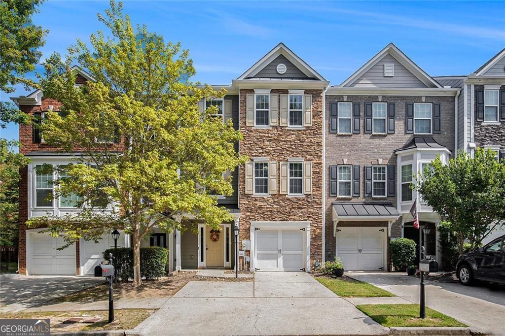 Beautifully maintained 3-bedroom, 3.5-bath townhouse in the desirable Suwanee Station community. This updated home features hardwood floors throughout the main living areas, a modern open-concept kitchen with quartz countertops and stainless steel appliances, and a cozy living room with a gas-log fireplace. Upstairs includes two spacious bedrooms with en-suite baths and walk-in closets. The lower-level bedroom offers flexible use-perfect as a home office, guest suite, or bonus room. Enjoy a private deck for outdoor living, a one-car garage, and an additional parking deck for extra convenience. Community amenities include a clubhouse, pool, tennis courts, and sidewalks. Ideally located with quick access to I-85, and just minutes from Suwanee Town Center, Sims Lake Park, Suwanee Greenway, shopping, dining, and top-rated schools.