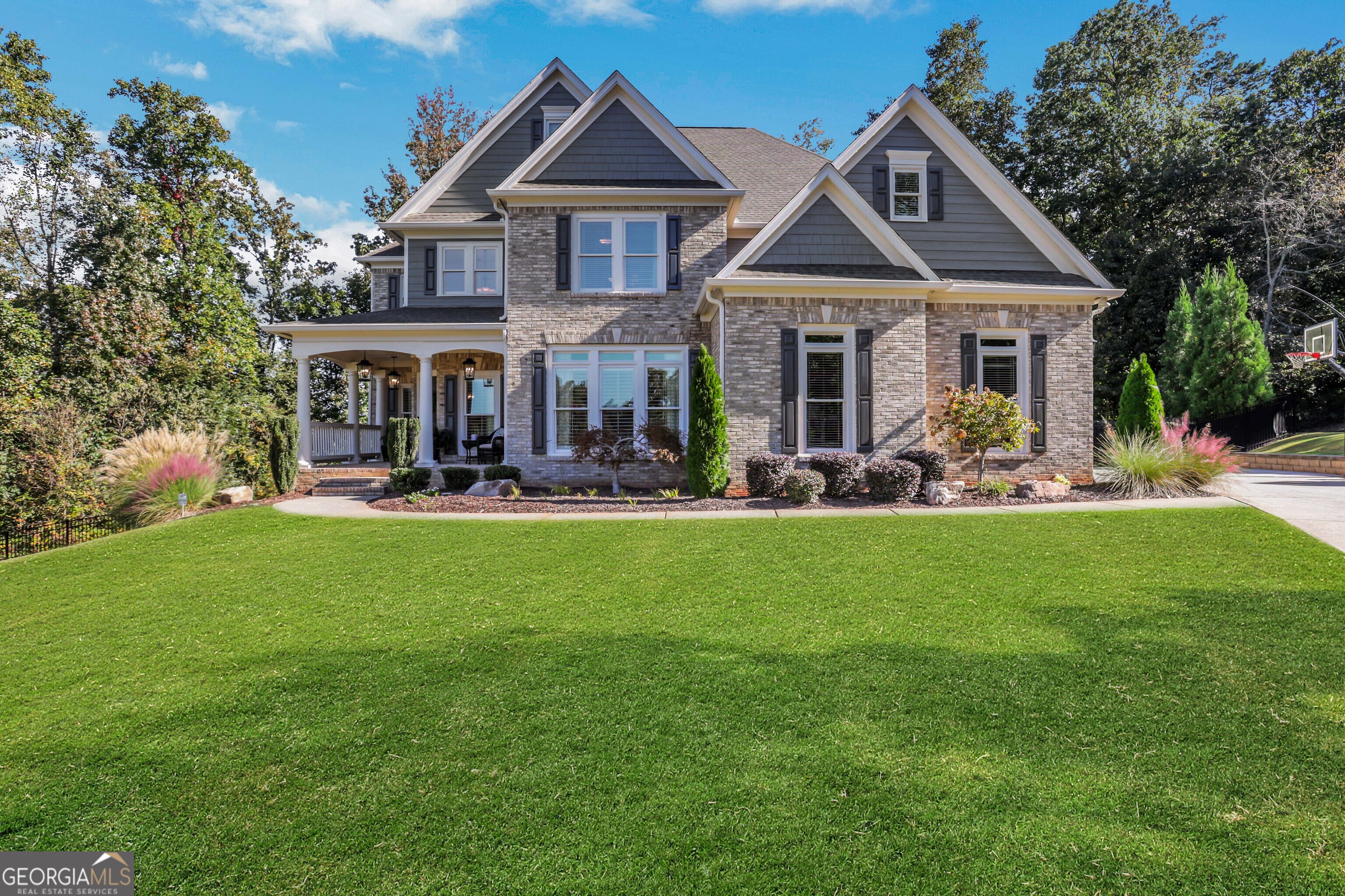 Tucked away on a peaceful cul-de-sac, this meticulously maintained 3-sides brick home stands out with its timeless curb appeal, inviting front porch, and incredible outdoor oasis. Step inside to rich hardwood floors, soaring ceilings, and walls of windows that fill the home with natural light. The main level offers a private office-perfect for working from home-and an elegant dining room ideal for hosting family and friends. At the heart of the home, the updated kitchen impresses with quartz countertops, high-end stainless steel appliances, and an extended island that opens seamlessly to the two-story great room. It's the kind of space that makes both everyday living and entertaining feel effortless. Upstairs, the spacious primary suite is a true retreat with a spa-inspired bath, soaking tub, oversized glass shower, dual vanities, and a large walk-in closet. Three additional bedrooms-one with a private ensuite and two sharing a Jack-and-Jill bath-offer comfort and flexibility for everyone. Also upstairs you'll find the laundry room. The fully finished basement is designed for fun and function with a game room, full kitchen, bedroom suite, ample storage, and the best home theater on the market-complete with stadium seating. Step outside and enjoy your own private backyard oasis with sparkling pool, waterfall feature, oversized hot tub, screened-in deck, and side porch. A tankless water heater, 3 car side-entry garage and thoughtful updates throughout make this home as efficient as it is beautiful. Located in Ashebrooke, one of the area's most vibrant and social communities, known for holiday celebrations, pool parties, tennis leagues, and neighborhood gatherings. Just minutes from Big Creek Greenway, Cumming City Center, GA 400, shopping, dining, and top-rated West Forsyth schools. More than a house-this is a place where life slows down, laughter comes easily, and memories are made to last.