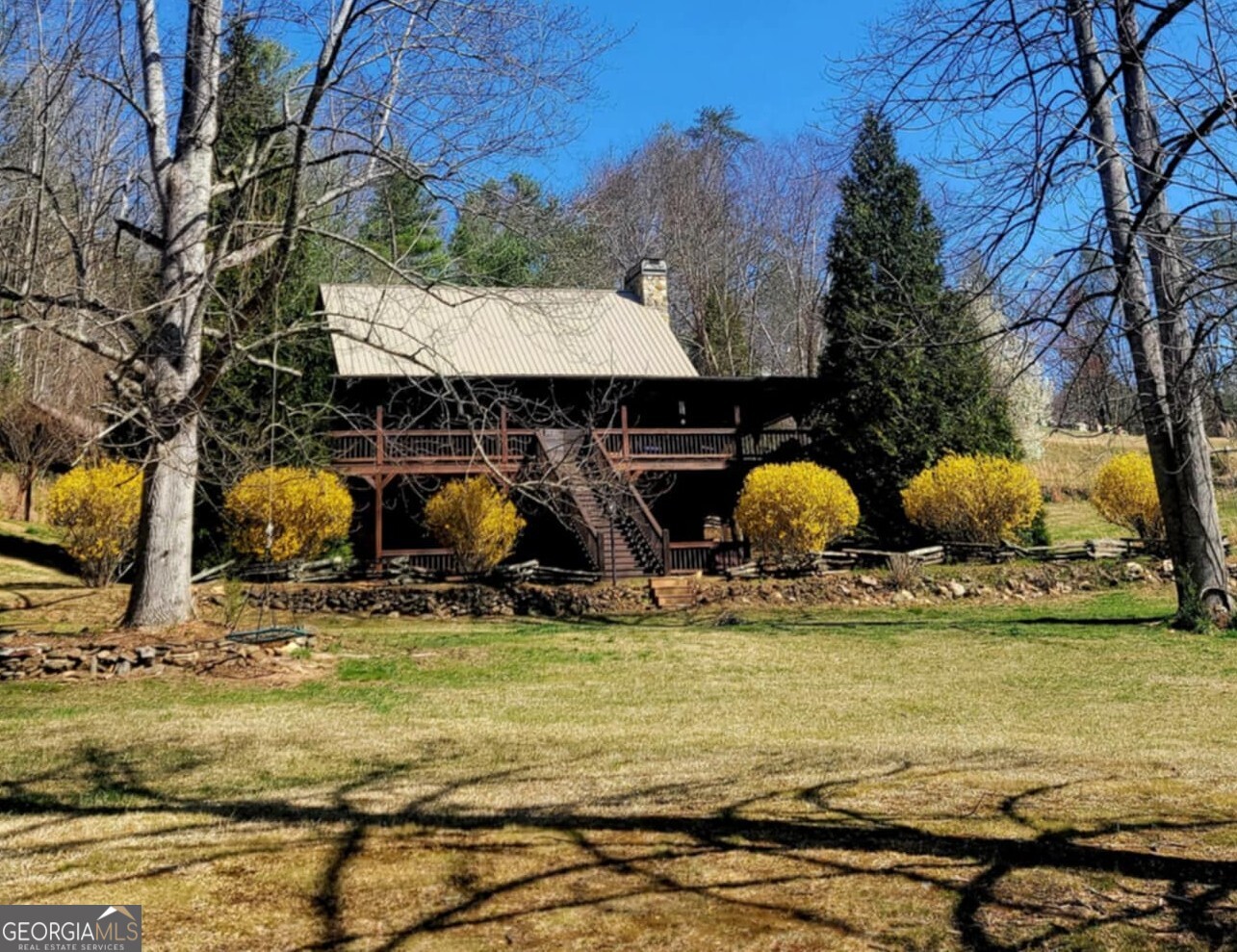 10/10 recommend this porch in every season! And while you're going to love the porch, the yard ranks right up there with it! This property offers PEACE & QUIET like no other! Expect wildlife in view on the daily and enjoy being minutes from access to the Toccoa River and Aska Adventure Area! This home features a Master Bedroom Loft with attached Master Bath, a Guest Room on the main level with a full bath that's easily accessible for visitors, and two additional bedrooms with a full bath in the basement area. One bedroom in the basement is a recent addition and you will not want to miss this cozy space! The walk-out basement is both spacious and practical, with ample entertaining and flex space. The kitchen is a joy for those who love to cook or entertain, featuring a gas stovetop and two ovens, wine fridge, coffee bar, and an oversized island. Prefer to dine in town? The cabin is only 12 minutes from downtown Blue Ridge! Looking to enjoy dining and shopping in Ellijay and Blairsville? Both are 30 to 35 minutes away! With two fully functional traditional fireplaces and an electric heater in the basement area, you'll love the ambience! Internet is top notch here (fiber!) - so while you may choose to "disconnect," you can certainly work with ease when needed. The oversized 3 car garage has a tremendous flex space that could be finished overhead and currently features a cedar closet. Whether you are looking for a home away from home or a permanent residence, this cabin checks many boxes!