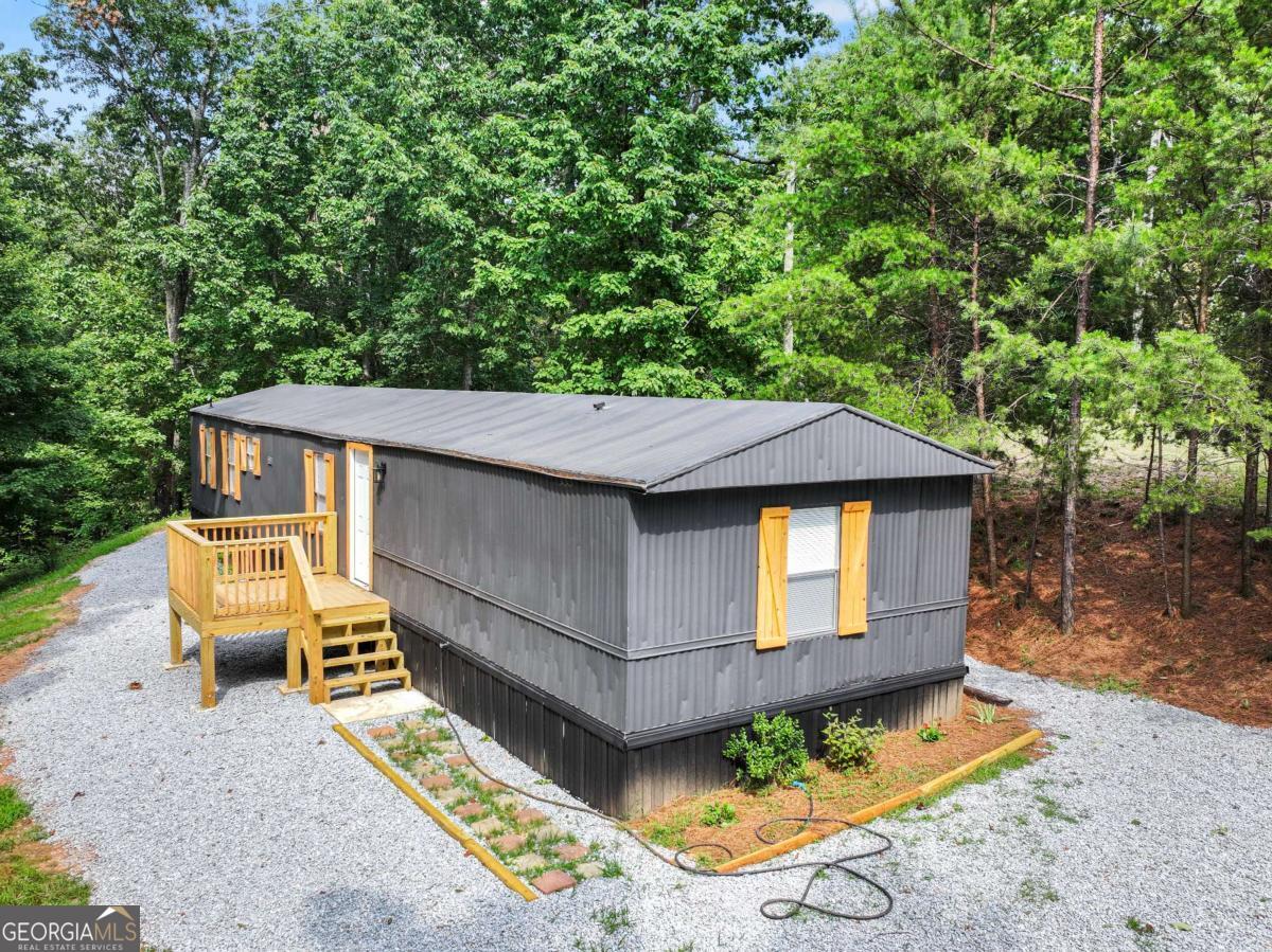 Tucked away on a peaceful, wooded lot, this fully renovated 3-bedroom, 2-bath home is the perfect escape for those who live for the outdoors. Whether you're into hunting, hiking, trail riding, or simply unwinding in nature, this property offers the space and freedom to do it all. Step inside to find a fresh, modern interior with brand-new flooring, updated lighting, and a bright open-concept layout. The kitchen features stylish finishes and plenty of prep space, ideal for cooking up a hearty meal after a day in the woods. The primary suite includes a spacious bathroom and walk-in closet, creating a cozy retreat all your own. Outside, the real adventure begins. Surrounded by mature trees and wildlife, the property offers endless possibilities-build a fire pit, set up hunting blinds, or explore the natural trails right from your backyard. With no HOA and plenty of room for your trucks, trailers, and gear, this property is made for freedom.