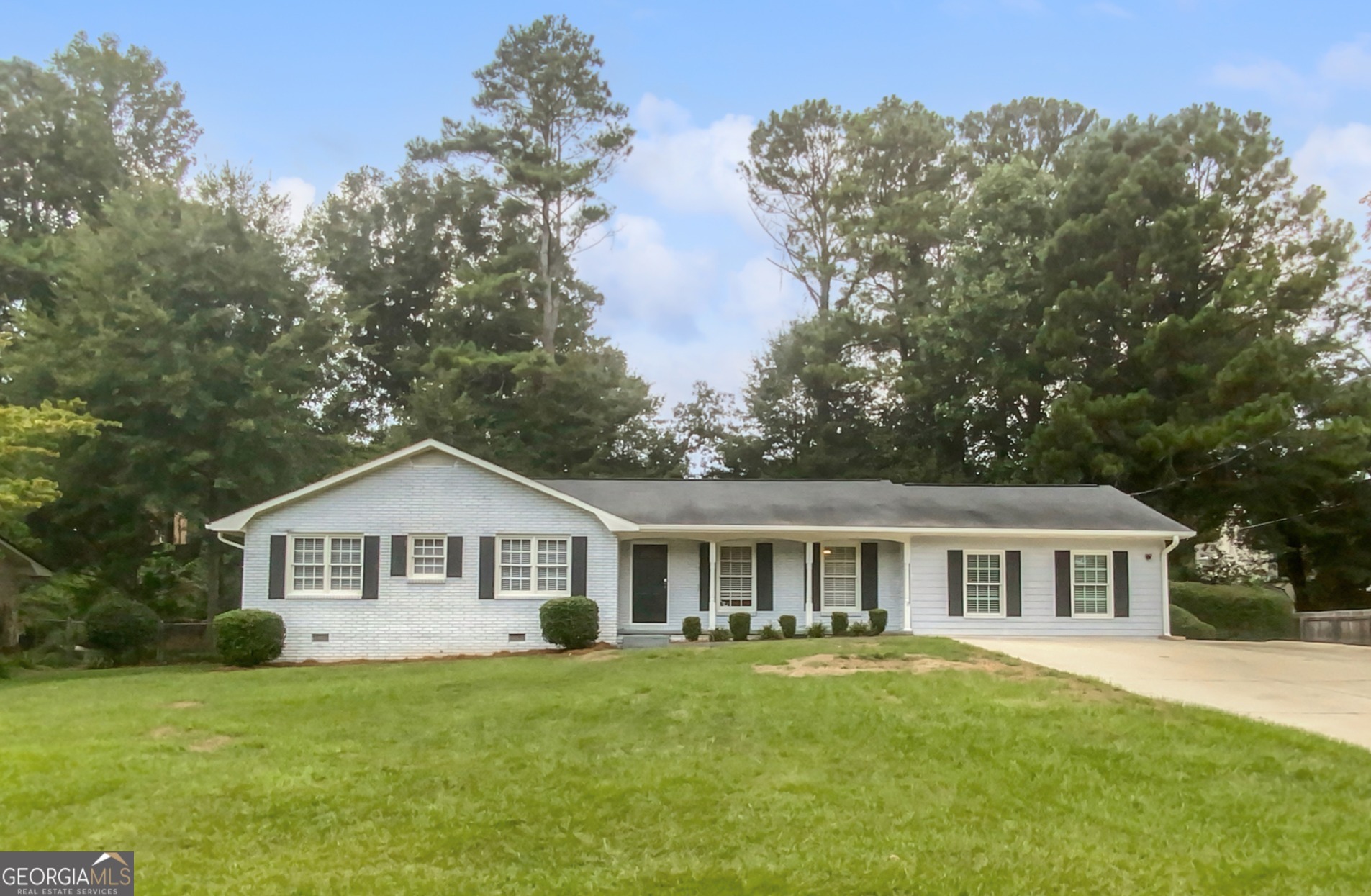 This charming brick ranch, situated in the highly sought-after East Cobb Wheeler School District, offers a welcoming blend of comfort and style. Step inside from the inviting covered front porch to discover a beautifully maintained home with a bright, open floor planCoperfect for entertaining. Gleaming hardwood floors flow seamlessly from the cozy family room, complete with a fireplace, into the sunlit dining area at the heart of the home. The spacious kitchen is a chef's dream, featuring stainless steel appliances, elegant marble countertops, and a custom tile backsplash. Retreat to the private owner's suite, which boasts an ensuite bathroom with a stunning subway tile shower. Two additional bedrooms share a hall bathroom equipped with a double vanity, providing plenty of space for family or guests. The converted garage, featuring a large walk-in closet, offers flexibility as a potential fourth bedroom, bonus room, or home office. Step outside to the tranquil, tree-lined backyard, perfect for relaxing or hosting gatherings. The deck, storage shed, and firepit patio create an ideal outdoor living space. This home is conveniently located just minutes from The Battery, Historic Marietta Square, Chattahoochee River National Park, and offers easy access to I-75. Don't miss this exceptional opportunity to enjoy modern living in a prime location!