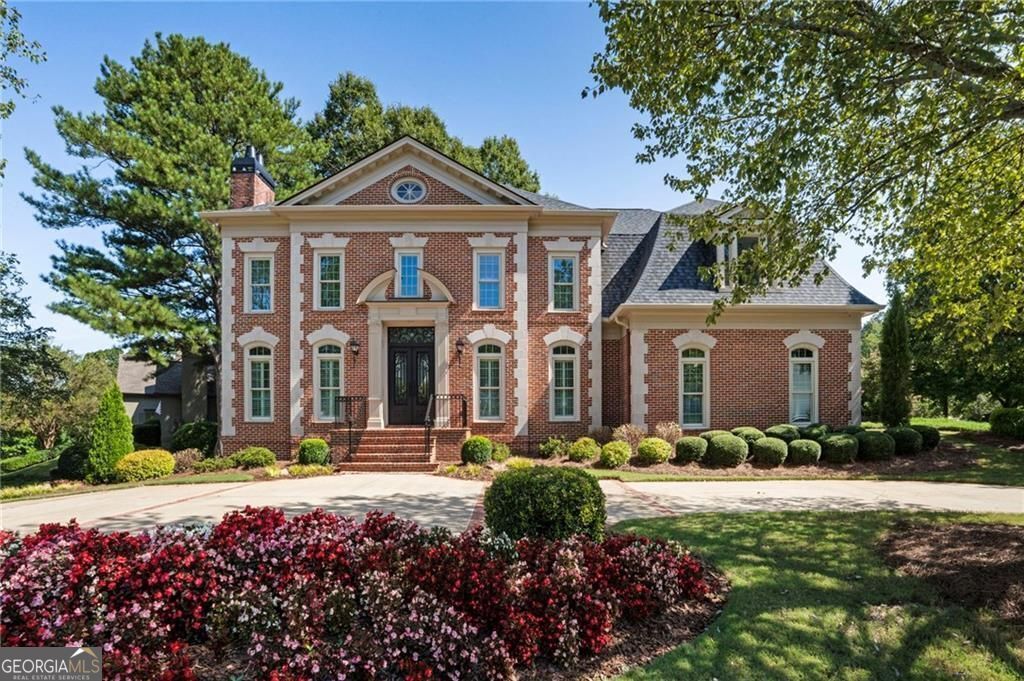 Welcome to this exceptional custom-built residence, showcasing superior craftsmanship and timeless design in the heart of East Cobb. Designed by Rick Green and situated within the sought-after Sope Creek Elementary district, this timeless brick Federal-style home offers just under 5,000 square feet of beautifully planned living space. From here, you can walk to Sope Creek Elementary, the scenic Chattahoochee National Forest, and the popular Sope Creek Trails - blending everyday convenience with outdoor recreation at your doorstep. Step inside to a dramatic two-story foyer, where abundant natural light, hardwood floors, and detailed millwork create a warm and elegant first impression. To one side, a handsome fireside study provides the perfect setting for a private office or library. To the other, a sophisticated formal dining room sets the stage for hosting memorable gatherings. At the heart of the home, the chef's kitchen is outfitted with premium appliances - including a Sub-Zero refrigerator and wine cooler, Bosch microwave, gas range, and dishwasher - making it as functional as it is stylish. An adjoining breakfast room and an open-concept fireside family room with custom built-ins create a comfortable flow for daily living. The main level also offers a guest suite with full bath, plus a conveniently located powder room for guests. Upstairs, the owner's retreat is a true sanctuary, complete with a newly renovated spa-like bath featuring dual vanities, a soaking tub, and a beautifully tiled shower. Three additional bedrooms and a versatile flex space complete the second level: one bedroom with en-suite bath and two bedrooms sharing a Jack-and-Jill design. Brand-new carpet throughout enhances the fresh, move-in-ready feel. Additional highlights include a three-car garage - a two-car garage on the main and a a third drive-under one-car garage with circular driveway - as well as fresh interior and exterior paint. Located in Sibley on Paper Mill, an exclusive swim/tennis community, this home combines neighborhood amenities with prime accessibility. Enjoy close proximity to The Battery, I-75 Express Lanes, Buckhead, Midtown, and many of Atlanta's top private schools, all while benefiting from favorable Cobb County taxes.