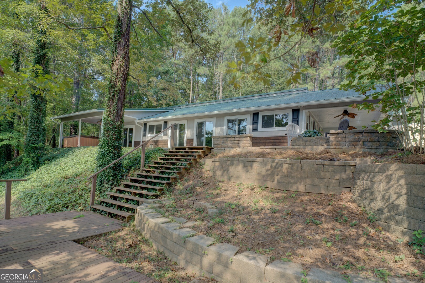 Looking for level-entry, easy access, and a beautifully updated home on a private, spacious lot in the highly desirable Tussahaw area of Jackson Lake? This 3-bedroom, 3-bathroom ranch offers just that-with thoughtful design, modern updates, and a deep-water lakefront lifestyle. No stairs from the car to a huge open great room/kitchen with a wall of windows that bring the outdoors in, connecting the living space to an expansive patio and cozy fire pit-ideal for relaxing evenings under the stars. The split-bedroom layout ensures privacy, featuring a large primary suite with outstanding lake views. Additional bedrooms are well-placed, each with access to their own full bath. Wake up to breathtaking water views and enjoy the seamless flow of the open floor plan, perfect for entertaining. A separate suite with its own entrance, kitchenette, and living area provides flexible options for extended family stays, a teen retreat, or a private home office. The entertainment area offers endless potential for a home theater or game room. Outside, enjoy 187 feet of pristine Jackson Lake shoreline, with plenty of room to expand, add a detached shop, or build an extra garage. The property is approved for a double-slip covered max dock, giving you the opportunity to build a double-stall boathouse for all your lake toys. This property combines privacy, modern comfort, and prime lakefront living in one of Jackson Lake's most sought-after locations.