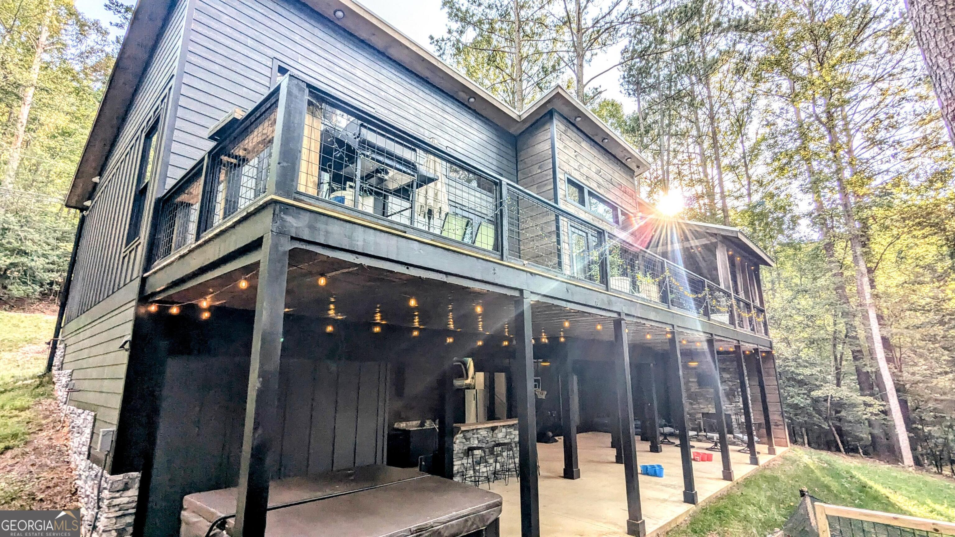 Welcome to this stunning 2023-built modern cabin offering 2,360 sq. ft. of luxury living space on 0.9 acres with 100 feet of private creek frontage. This 3-bedroom, 3-bath home blends rustic charm with modern finishes and was designed for comfort, entertaining, and investment potential. Step inside to find soaring all-wood stained ceilings, a warm mix of shiplap and drywall accents, and abundant natural light throughout. Every detail was carefully selected: oversized 8-foot doors, all-wood flooring, and all granite countertops with under-cabinet lighting. The open-concept design includes a game room, three cozy gas fireplaces, and large bathrooms-two bedrooms feature walk-in closets. The outdoor spaces are just as impressive, with massive upper and lower porches, a hot tub, an outdoor wet bar, and a fire pit-perfect for entertaining year-round. Additional features include: Board and batten Hardie board siding with a full metal roof Buried propane tank for clean aesthetics. Completely paved driveway for easy access All wood-lined ceilings and quality craftsmanship throughout This property is being offered fully furnished as a turnkey rental, and the seller is willing to provide rental performance data to serious buyers. Whether you're looking for a forever home, a private retreat, or a proven investment, this one-of-a-kind modern cabin is ready to deliver.