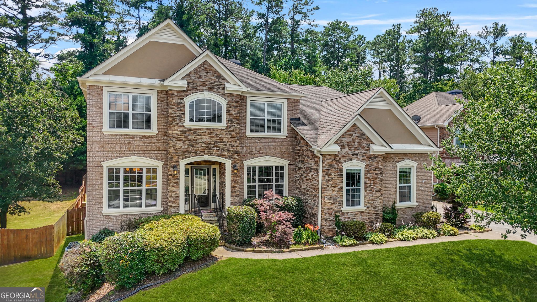 Welcome to this impressive 7 bedroom, 4.5-bath traditional beauty in sought after Woodland Chase! As you enter this residence, you'll be greeted by the bright and inviting two-story foyer with a separate formal dining room and formal living room. The main level features gleaming hardwood floors, plus a dreamy eat-in kitchen with granite countertops, stainless steel appliances, stained cabinetry, and a seamless view into the family room with built-in shelving and a fireplace. Gorgeous natural light pours in, while the oversized deck off the kitchen provides an ideal setting for all types of gatherings. Enjoy the luxury of a first-floor primary suite that boasts a tray ceiling and lots of natural light. The primary bath features a jetted tub, separate vanities, water closet, separate shower, and a customized walk-in-closet. Upstairs, you'll find 5 generously sized bedrooms, offering versatility for guest rooms, home offices, or play areas, along with 2 additional bathrooms - Yes! There are 5 bedrooms upstairs! The finished basement is a highlight-designed as an in-law suite complete with a full kitchen, living area, bedroom, and bath-ideal for guests, multi-generational living, or rental income potential. This spacious home is complete with two laundry rooms, a convenient side-entry 2-car garage, and a fully fenced backyard that sits near a cul-de-sac-perfect for privacy and play. Located just minutes from West Cobb Aquatic Center, top shopping, dining, and major highways-this entertainer's dream home blends functionality and luxury beautifully. Don't miss out-homes like this in Woodland Chase move fast!