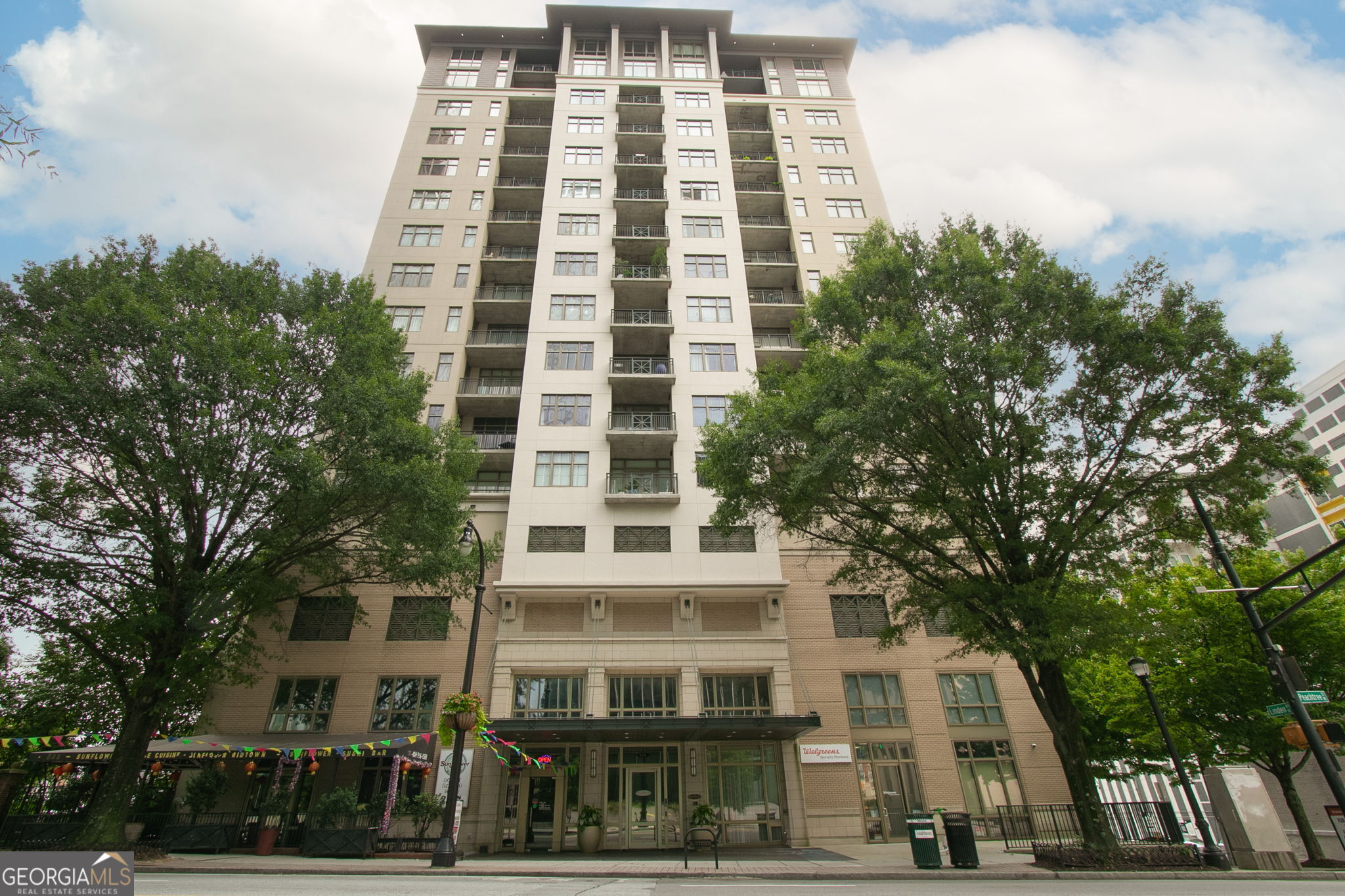 Enjoy elevated city living in this renovated 2 bed, 2 bath residence at The Reynolds, a premier full-service building in Midtown. Located on a high floor, this 1,380 square foot home features a renovated kitchen with stainless steel appliances, a pantry, and a convenient dry bar with beverage cooler. The expansive living area boasts motorized shades for views when you want them and privacy when you don't. Custom closets throughout provide ample storage options. Both bathrooms have been renovated; the primary bathroom features a dual vanity with marble countertops and a custom steam shower. Hardwood-style flooring throughout the home creates a clean aesthetic. The HVAC system is less than a year old, offering modern comfort and efficiency. Residents enjoy a 24-hour concierge and security, resort-style pool, fitness center, and clubroom-ideal for a true lock-and-leave lifestyle. This unit also includes two deeded parking spaces and a private storage unit. Unbeatable location just steps from Emory Midtown, Piedmont Park, the Fox Theatre, and some of Atlanta's best shopping and dining.