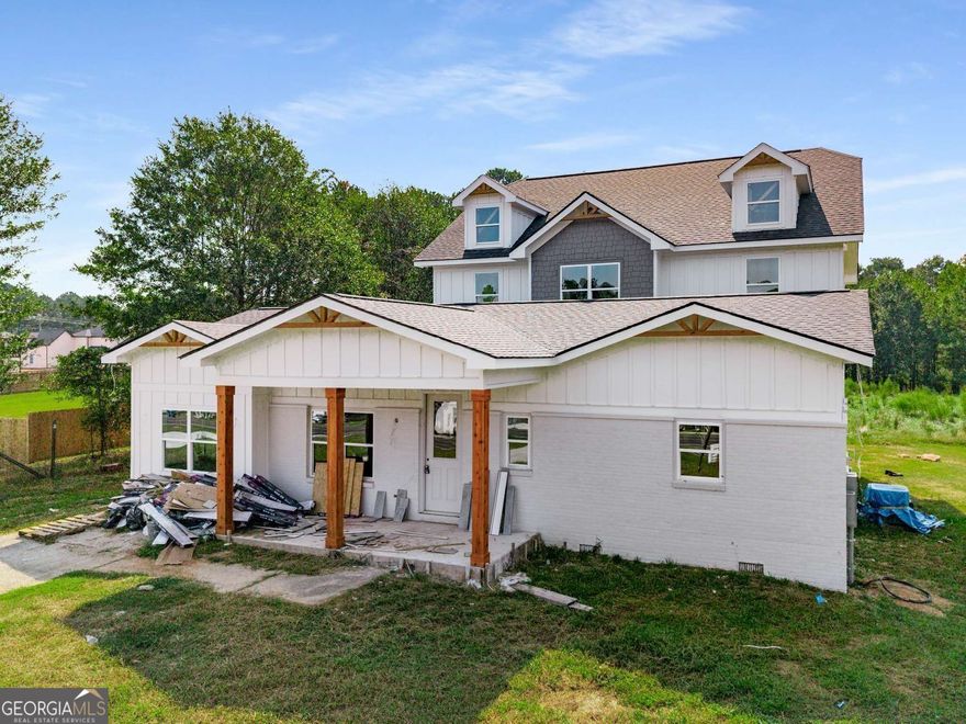 Welcome to 518 Hoke O'Kelly Mill Rd - a stunning new luxury residence in Loganville, move-in ready in November! This exceptional 4-bedroom, 3-bath home blends elegant design with modern convenience, showcasing premium finishes and meticulous craftsmanship throughout. The gourmet kitchen is a true centerpiece open concept to the vast living space. This area boasts quartz countertops, white shaker cabinetry, a stylish herringbone backsplash, a dramatic waterfall island, pot filler. The walk-in pantry is the envy of the best chefs. A built-in wine cooler-ideal for hosting with ease. On the main level, you'll find a private guest suite, a full bath, and a private flex room perfect for an office, hobby room, fitness room, playroom, or media space. Additional highlights include a convenient mudroom and dual living spaces-each featuring a sleek electric fireplace. Smart switches and voice-controlled lighting add a layer of comfort and sophistication to daily life. Upstairs, the luxurious primary suite offers a peaceful retreat complete with its own fireplace, dual walk-in closets, and a spa-inspired bath featuring a soaking tub, frameless glass shower, and floor-to-ceiling tile. Step outside to enjoy a spacious rear deck, a covered front porch, and the potential for both front and rear irrigation systems. A 3-car garage with rear entry is pleasingly removed from the front elevation. Thoughtfully designed for luxury, comfort, and connection, this new construction home delivers the perfect balance of elegance and everyday ease-without compromise.