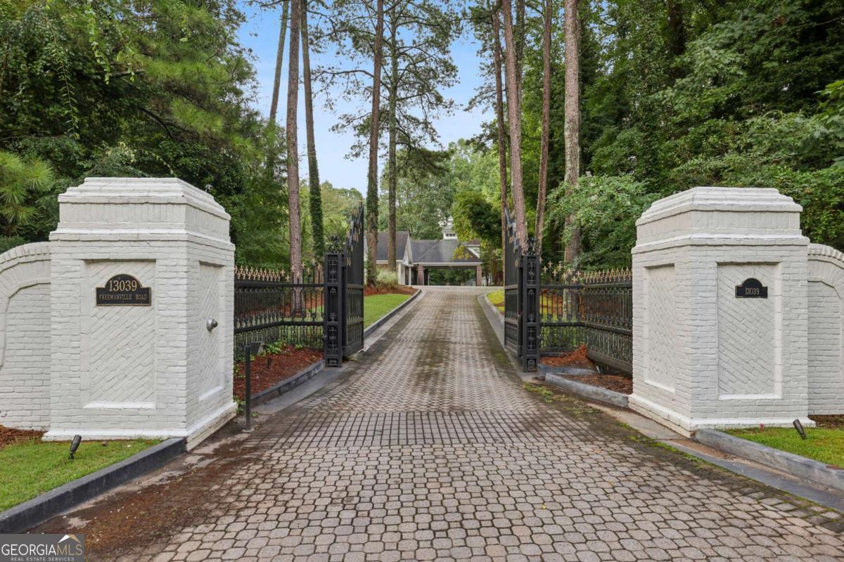 Welcome to 13039 Freemanville Road - A Private Luxury Estate in Alpharetta, GA Experience unmatched elegance and privacy at this exquisite gated estate nestled on one of Alpharetta's most prestigious roads. This luxury residence features 9 bedrooms and 10.5 bathrooms, designed with top-tier craftsmanship and custom finishes throughout. From the moment you enter through the gated drive and approach the beautifully landscaped grounds, you'll be captivated by the grand scale and timeless appeal of this exceptional home. Main Residence Highlights: Stunning Foyer with dramatic entrance and architectural details Elegant 12+ Seating Formal Dining Room perfect for entertaining Gourmet Chef's Kitchen featuring quartz countertops, custom cabinetry, gold fixtures, high-end stainless appliances, walk-in pantry, and a cozy keeping room with fireplace Luxurious Main-Level Owner's Suite with trey ceilings, a sitting area, and a spa-style custom closet Main Level: 3 spacious bedrooms / 3.5 bathrooms Upper Level: 4 bedrooms with en-suite baths including a generously sized Junior Owner's Suite and 4 full bathrooms Dual staircases for front and rear access Outdoor Living & Entertainment: Beautiful Courtyard with a tranquil fountain and an outdoor brick pizza oven 5-Car Garage with abundant storage Guest House & Studio/Office Guest House: 2-story entry, full kitchen, 2 bedrooms, 2 bathrooms, laundry Studio: Versatile space perfect for a bar, office, or content studio Wellness & Custom Features: 3 Fireplaces** throughout Infrared Sauna, Steam Room & Massage Parlor Impeccably maintained with high-end finishes and thoughtful design in every space Financing Flexibility: Seller is open to owner financing with flexible terms for qualified buyers - a great opportunity for those seeking creative financing options. Schedule your private tour today and experience the ultimate in luxury living at 13039 Freemanville Road. This one-of-a-kind estate won't last long.