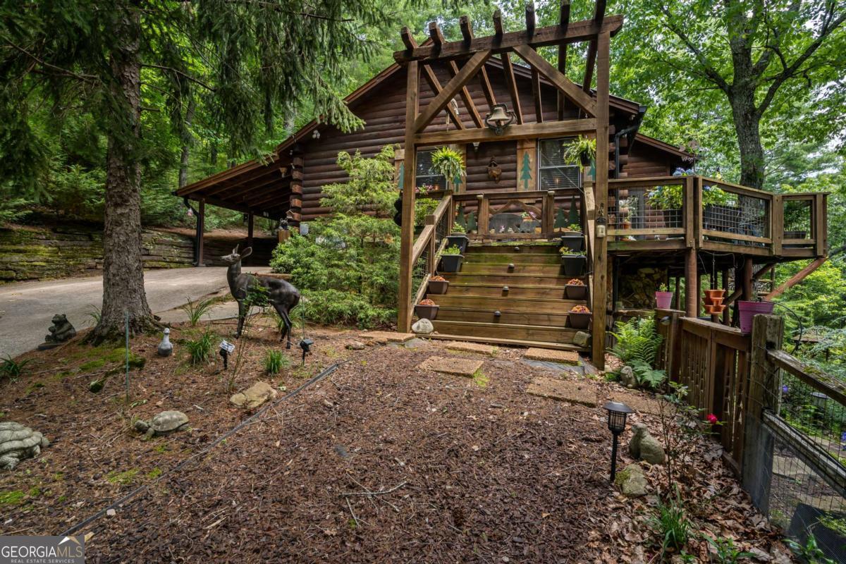 Nestled in the heart of the Blue Ridge Mountains, this beautifully crafted 3-bedroom, 2-bathroom log cabin offers the perfect blend of mountain charm and modern comfort. Situated on over 2 acres that boast long-range mountain views that will take your breath away. Step inside and enjoy the warmth of natural wood finishes, a cozy open-concept living area, and thoughtfully designed spaces for relaxation and entertaining. The highlight of the property is the expansive party deck, custom-built by renowned builder Keith Sumner, featuring a stunning outdoor fireplace and a relaxing hot tub-ideal for enjoying cool mountain evenings under the stars. Whether you're looking for a peaceful retreat, a family getaway, or a proven short-term rental investment, this cabin checks every box. Short-term rental eligible and ideally located with easy access to both Blue Ridge and Ellijay, it's the ultimate mountain escape. Home also comes equipped with a whole home generator and EV charger.