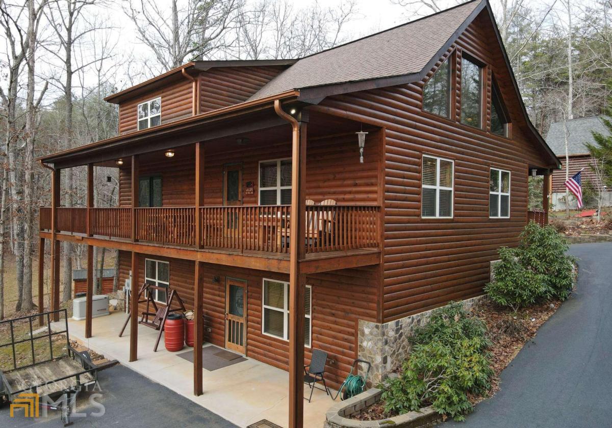 AMAZING ABUNDANCE in this LOG sided home on 4.95 Acres! Great room sizes and beautiful wood floors and ceilings, nice mixture of drywall and wood. Stone Fireplace, Masters on every floor. Full additional kitchen in lower level, lots of storage areas. Detached 2 plus garage with Bonus/Bedroom above with half bath. Wrap around porch, fire pit area, with exceptional landscaping. Bring all your lake toys, close to Lake Nottely and marina. Perfect areas for guests or live in family!