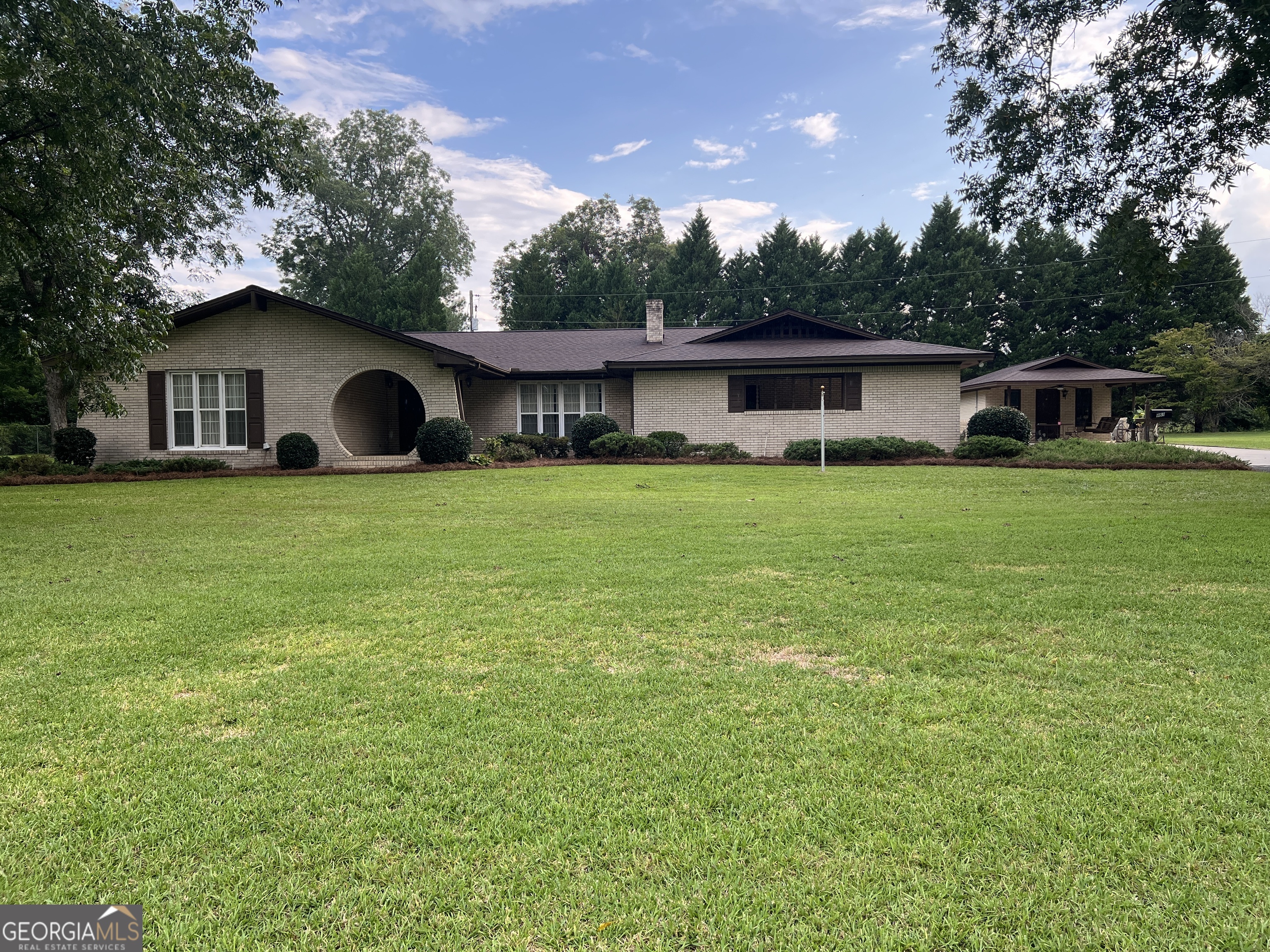 Beautifully updated and move-in ready, this all-brick home features 3 bedrooms, 2 bathrooms, and 2,273 square feet of living space on 1.21 acres. Enjoy an underground water system to water your flower beds and gardens. The storage building has a garage door on the back and porch and ceiling fan on the front. This could easily be renovated to use as a mother in law suite or apartment. Recent upgrades include brand new flooring throughout, fresh paint, and new stainless steel appliances, giving the home a fresh, modern feel. The spacious layout includes a versatile bonus room that can be used as an additional bedroom, office, or game room. A 2-car garage provides convenient parking and extra storage space. Located within one mile of elementary, middle, and high schools, this property offers both privacy and accessibility, making it an ideal choice for families seeking comfort, convenience, and room to grow. Additional Updates: Septic tank pumped, AC serviced by Locke Barlow, flood light bulbs replaced, new window AC in the bonus room/office, well was dug deeper in 2024, house and storage building stained, new CertainTeed Shingles on the house and storage house in 2019. Call or text Misty Oxford at 478-231-0568 to schedule your tour of this beautiful property. SHOWINGS WILL BEGIN ON 9/21/2025.